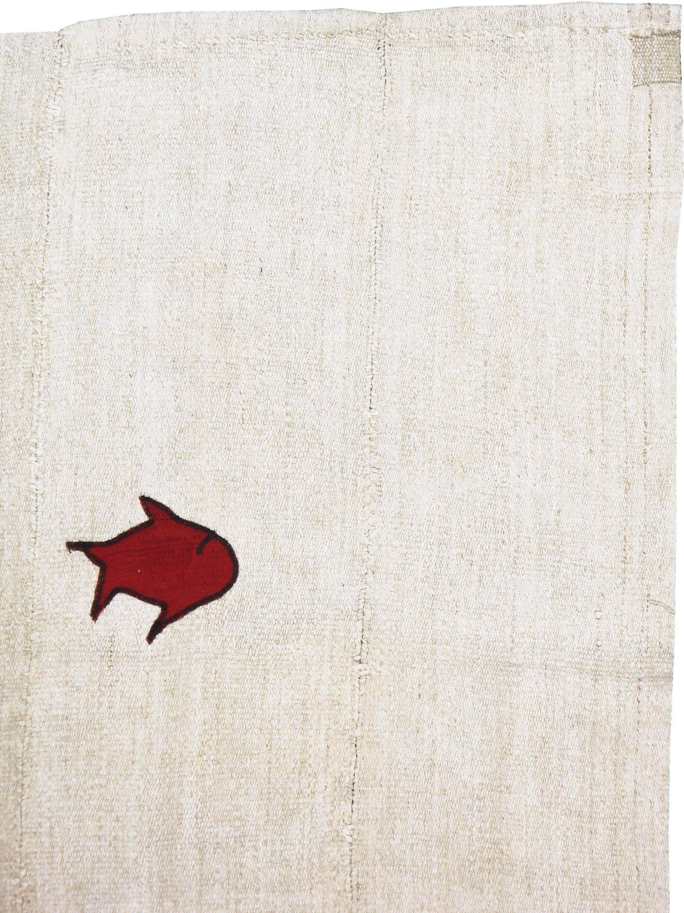 Un Kilim turc moderne du 21ème siècle. Le tapis se compose d'un Kilim vintage en chanvre comme fond blanc et de taches en relief pour former le motif. Pas de bordures, mais une mer écrue finement abrasée (stries de couleur naturelle) avec quatre