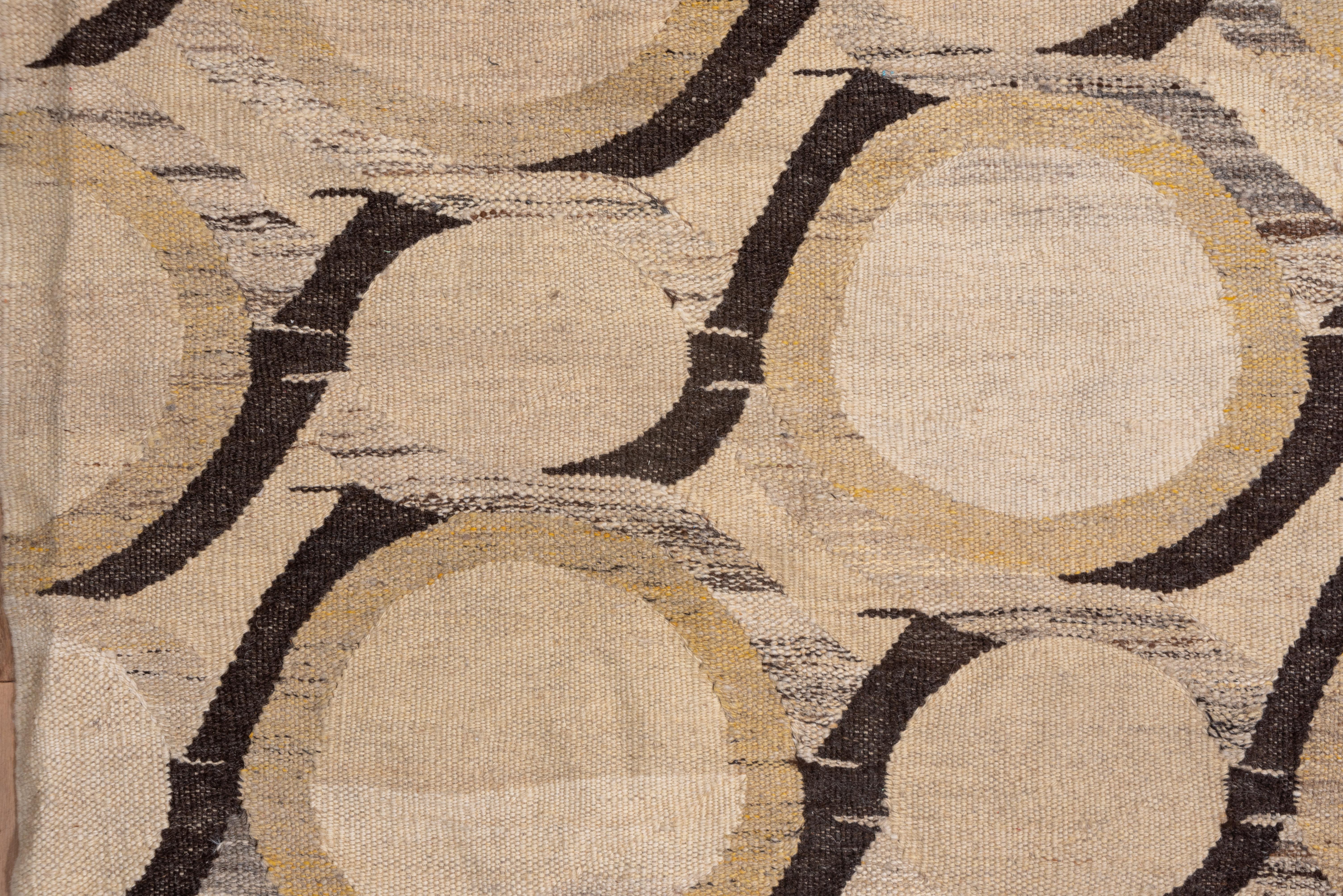 This borderless modern flat-weave actually features rows of twisted brown ribbons making larger and small open reserves on an ecru ground, but the visual effect is of a flowing diagonal. Ecru ground and contemporary with a tritone palette.
  