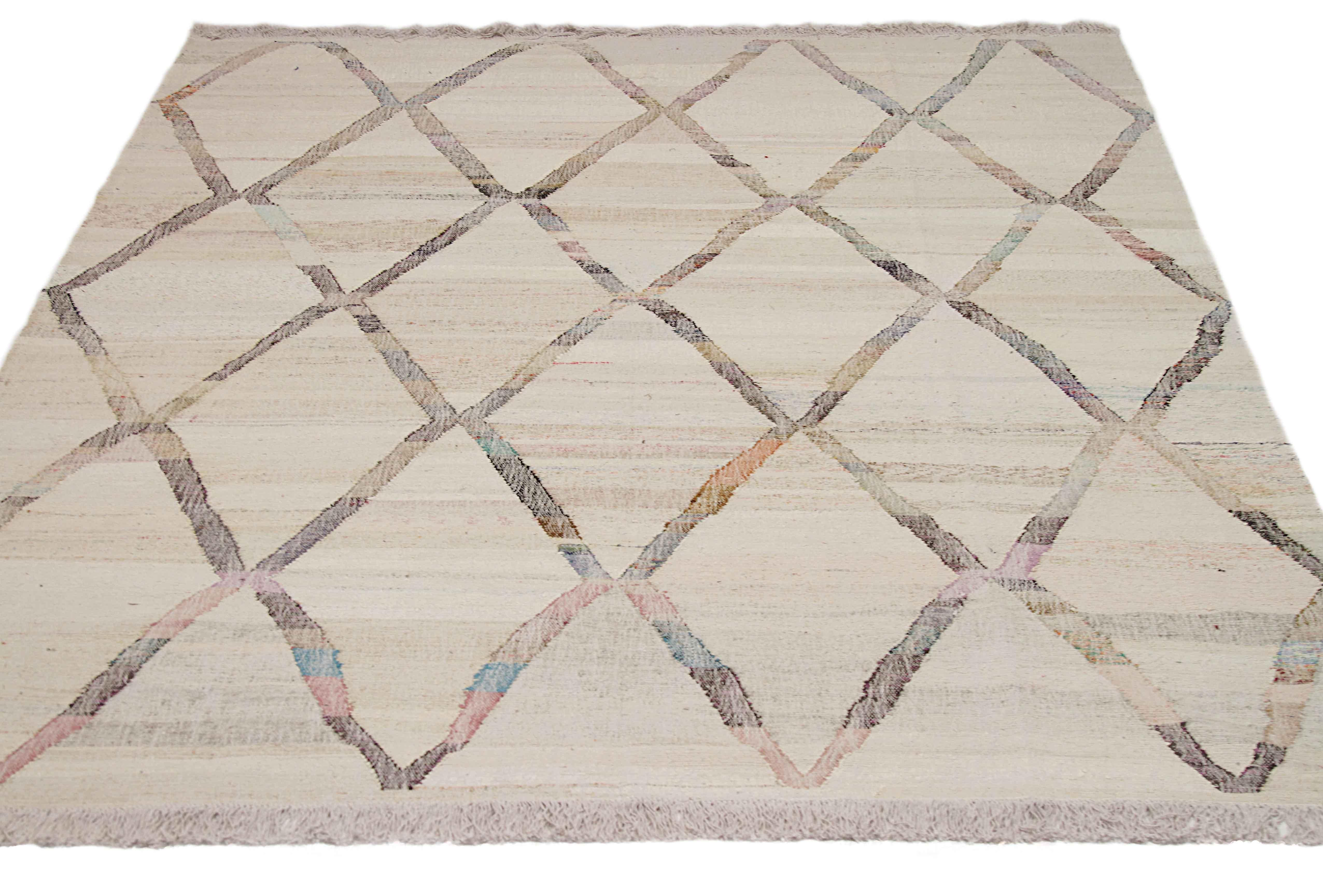 New Turkish rug handwoven from wool taken from antique fine carpets. It’s a traditional Kilim weaving featuring a diamond mesh pattern in vibrant colors over an ivory field. It’s a stunning piece to get for contemporary and modern spaces. It has a