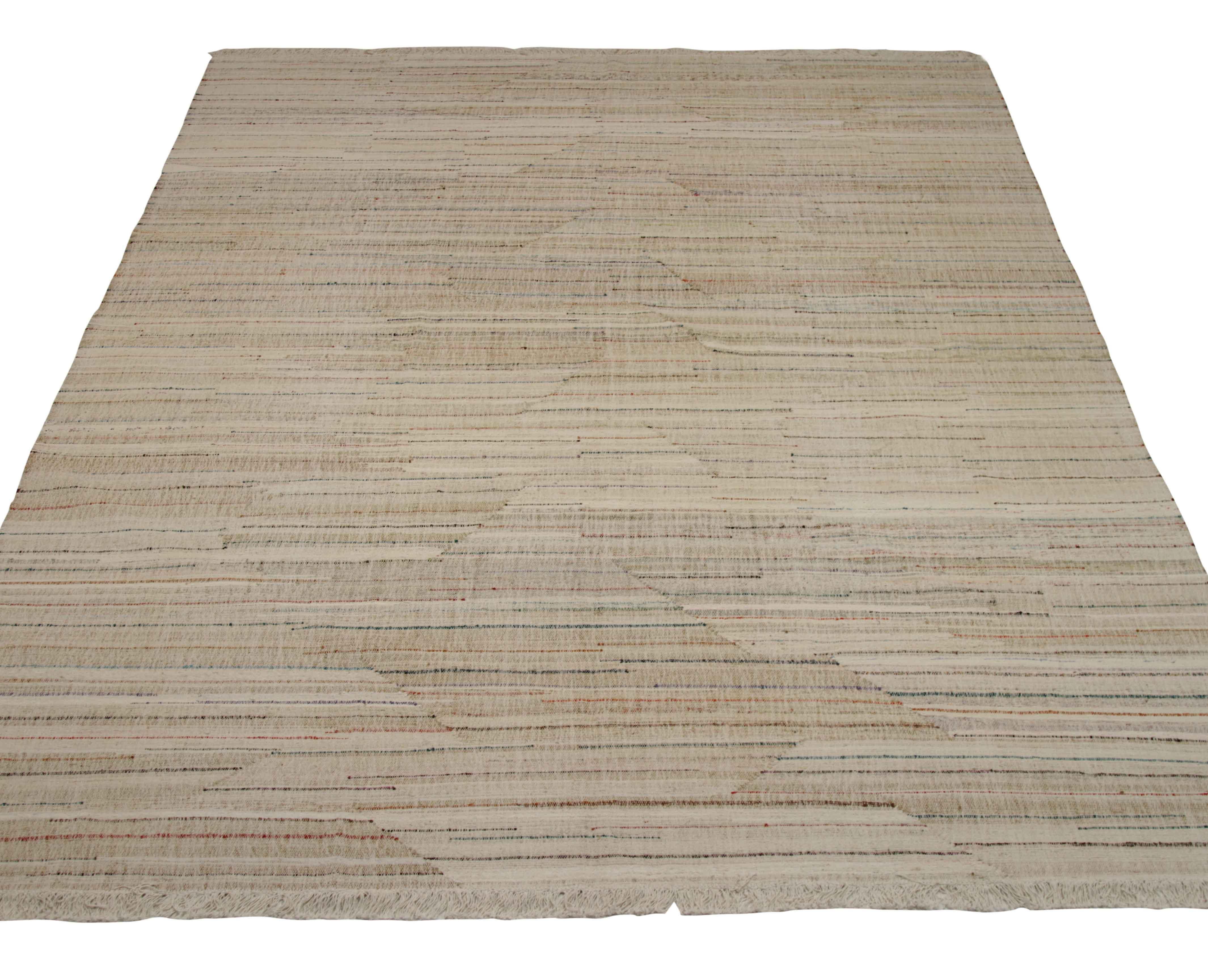 New Turkish rug handwoven from wool taken from antique fine carpets. It’s a traditional Kilim weaving featuring colored lines over an ivory field. It’s a stunning piece to get for contemporary and modern spaces. It has a dimension of 9’10” x 13’9”