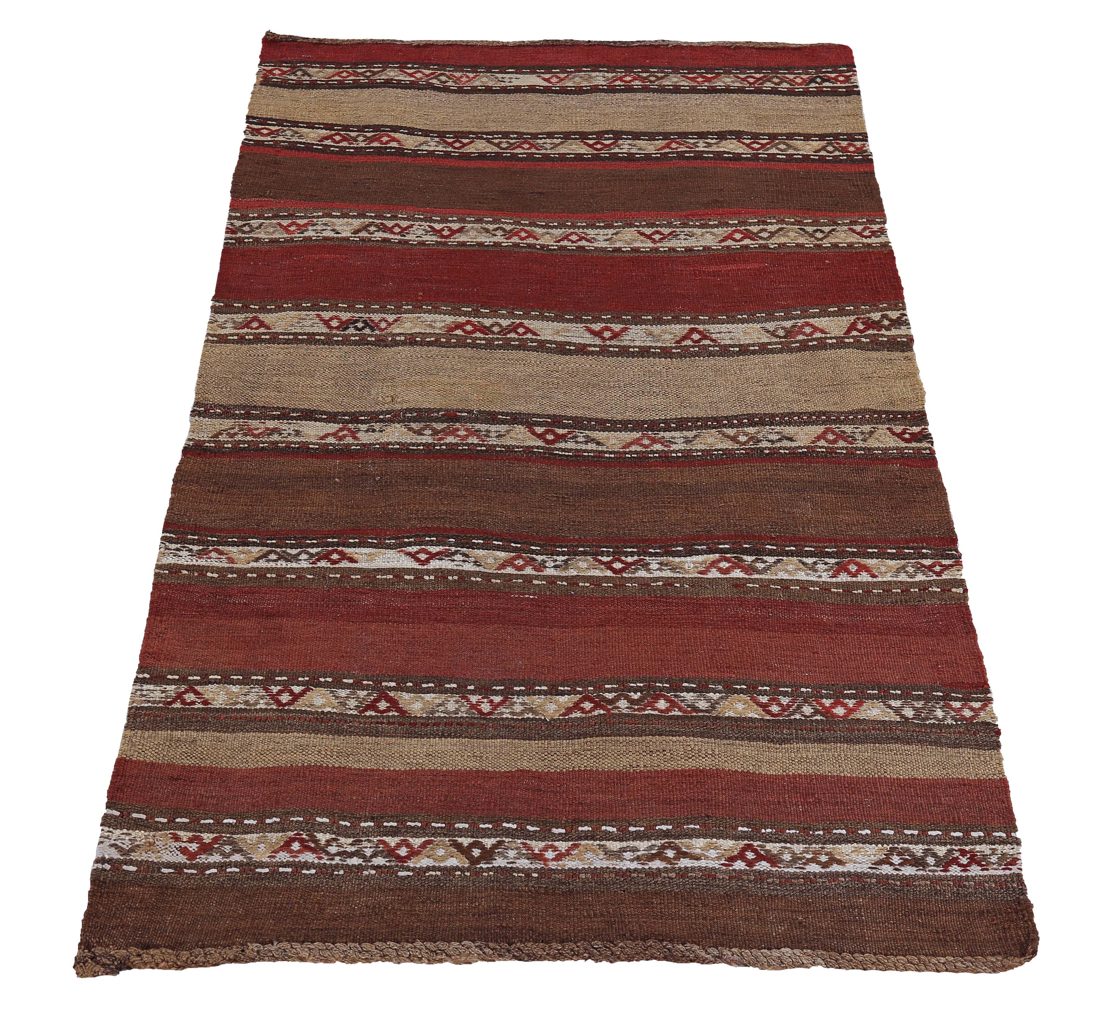 Turkish rug handwoven from the finest sheep’s wool and colored with all-natural vegetable dyes that are safe for humans and pets. It’s a traditional Kilim flat-weave design featuring beige and rust stripe tribal patterns on a brown field. It’s a