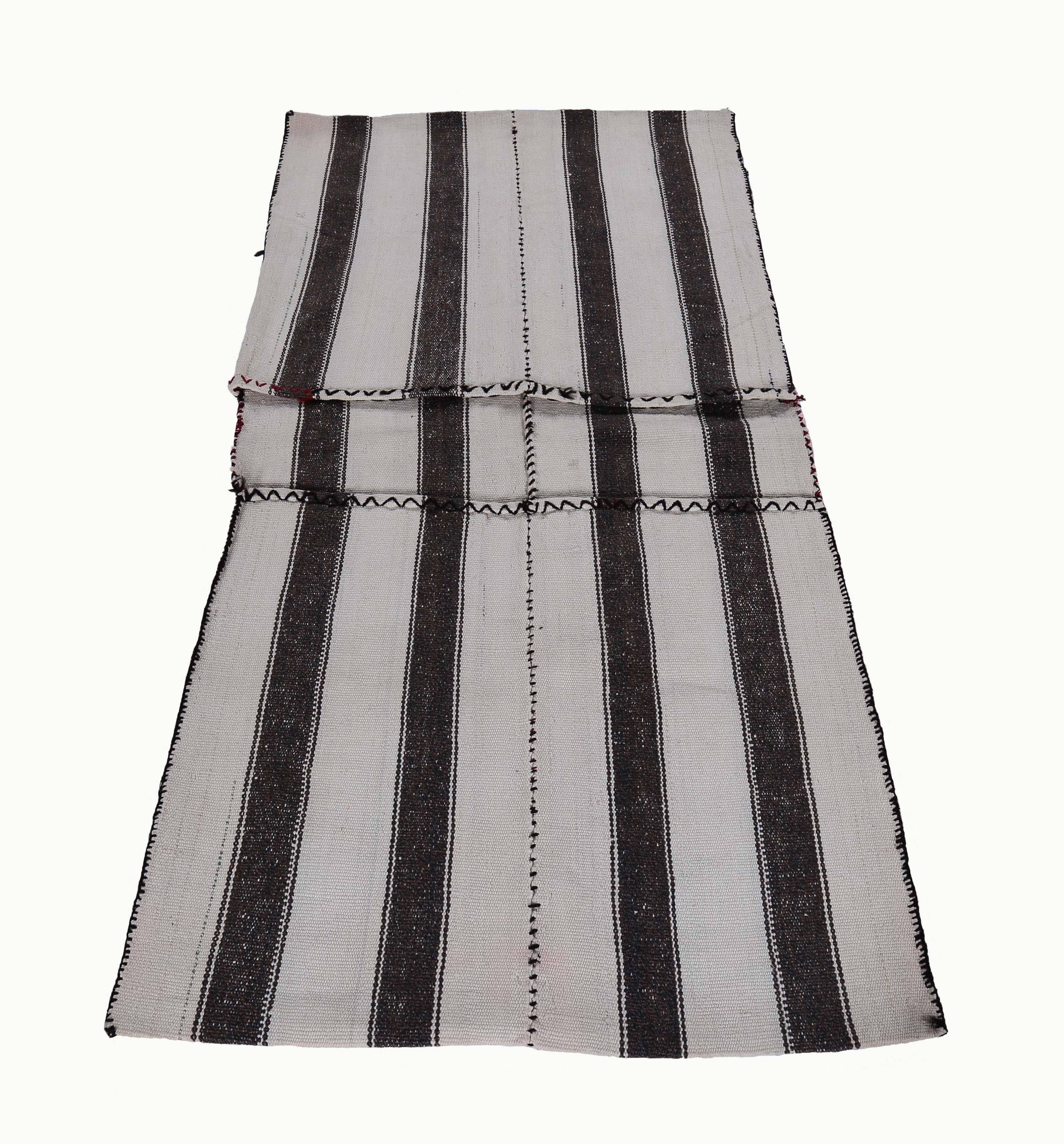 Turkish rug handwoven from the finest sheep’s wool and colored with all-natural vegetable dyes that are safe for humans and pets. It’s a traditional Kilim flat-weave design featuring black stripes in a white field. It’s a stunning piece to get for