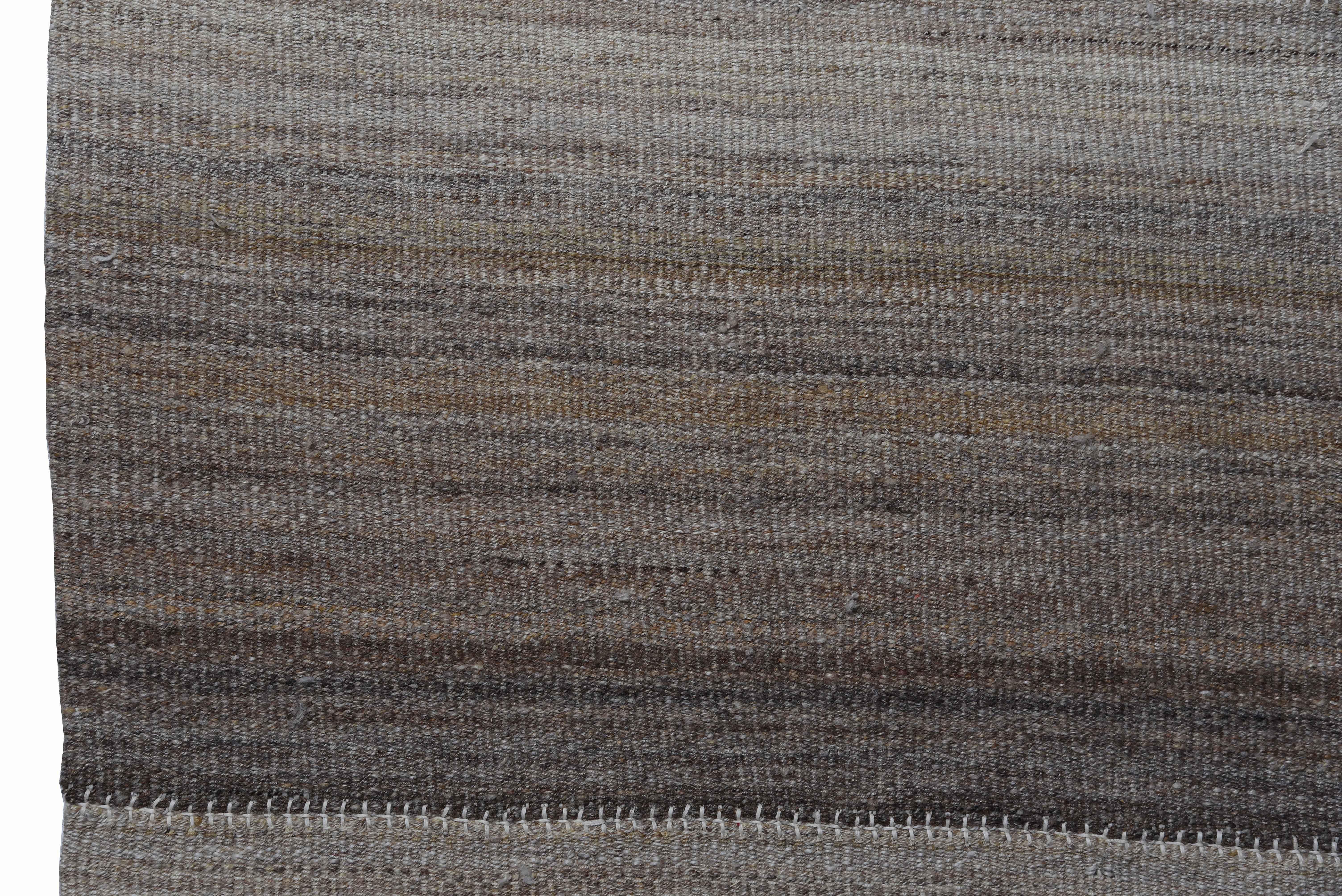 Modern Turkish rug handwoven from the finest sheep’s wool and colored with all-natural vegetable dyes that are safe for humans and pets. It’s a traditional Kilim flat-weave design featuring modern brown and gray stripes on an ivory field. It’s a