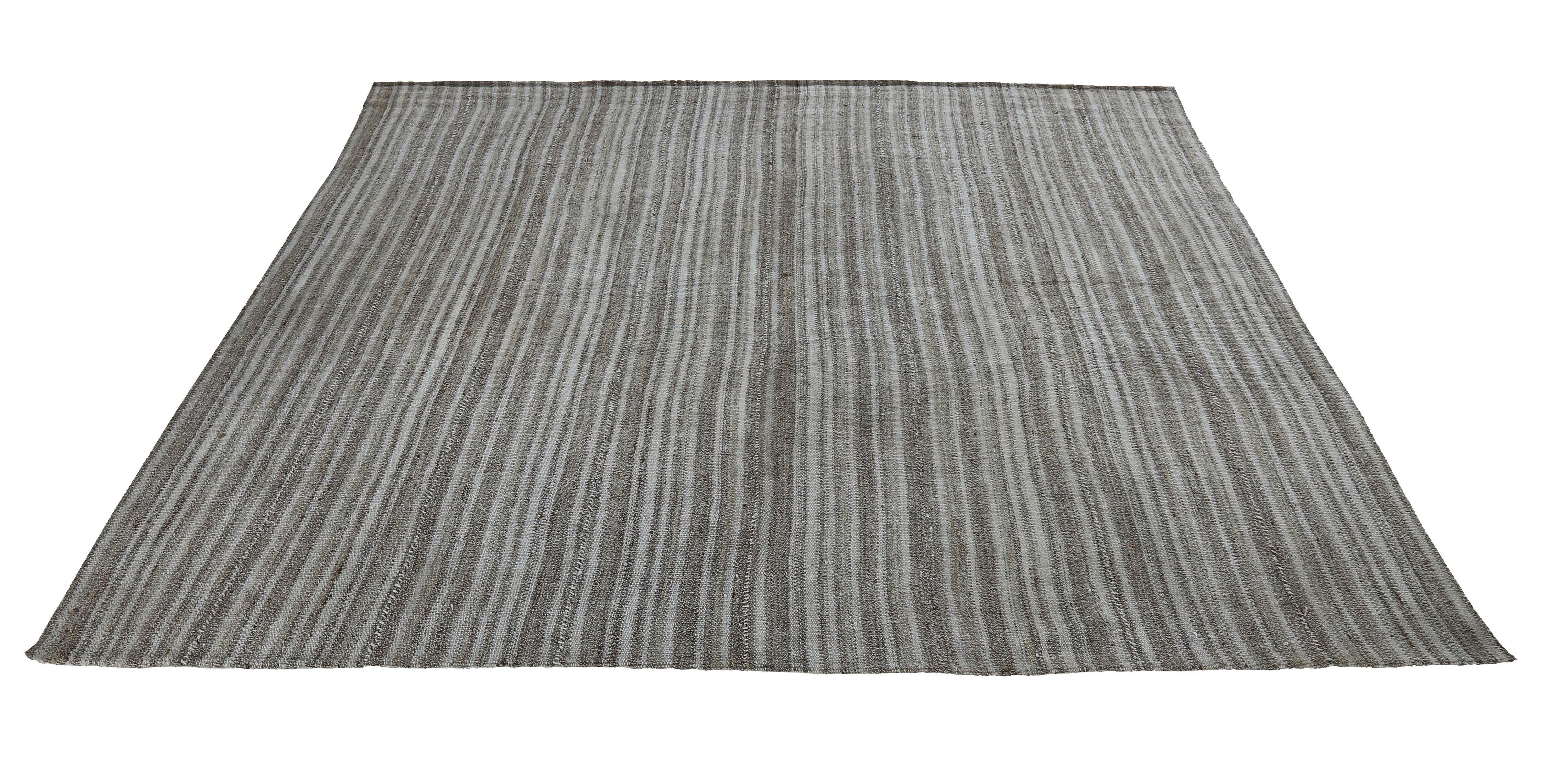 Modern Turkish rug handwoven from the finest sheep’s wool and colored with all-natural vegetable dyes that are safe for humans and pets. It’s a traditional Kilim flat-weave design featuring a gray field with brown pencil stripes. It’s a stunning