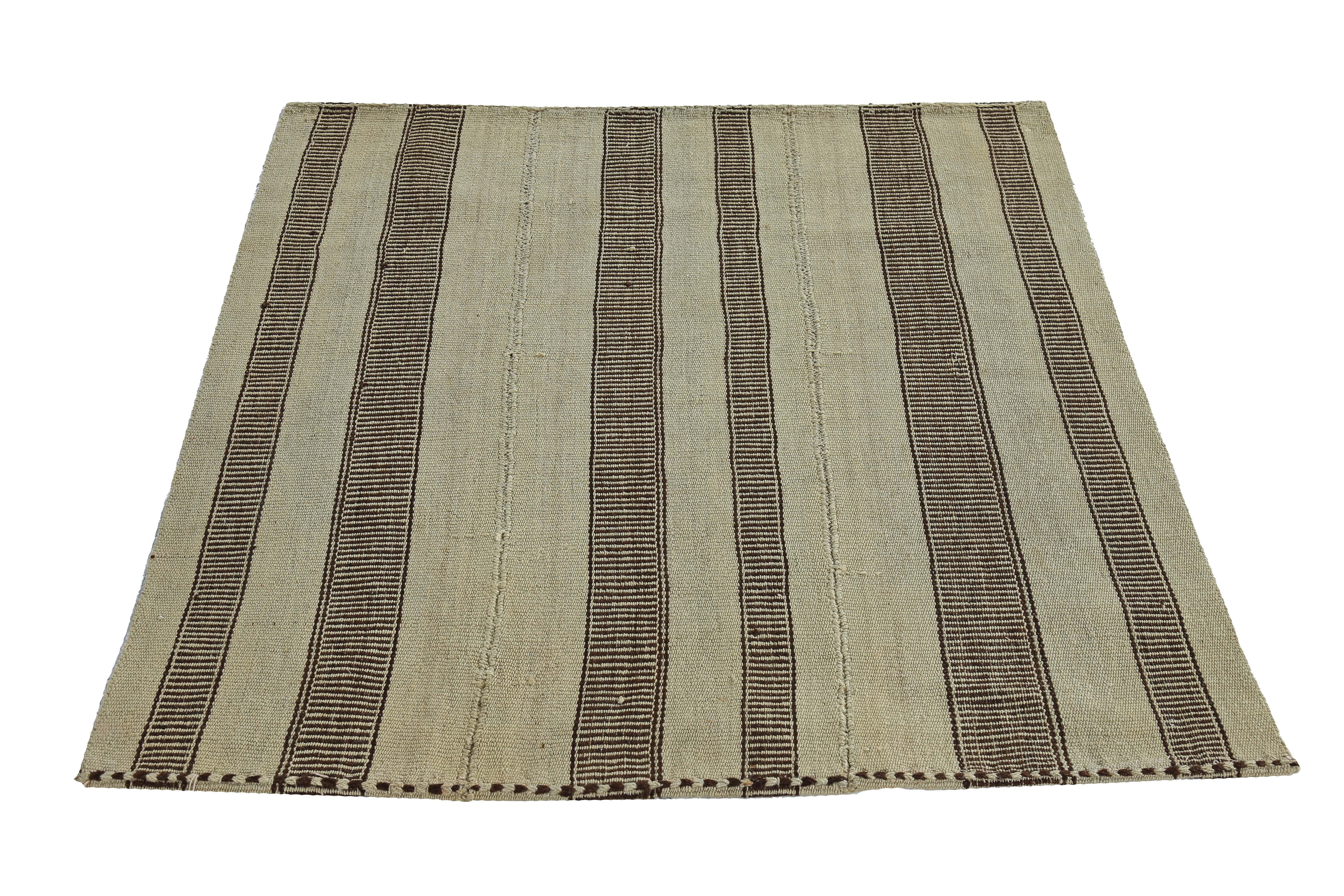 Turkish rug handwoven from the finest sheep’s wool and colored with all-natural vegetable dyes that are safe for humans and pets. It’s a traditional Kilim flat-weave design featuring brown stripes on a beige field. It’s a stunning piece to get for