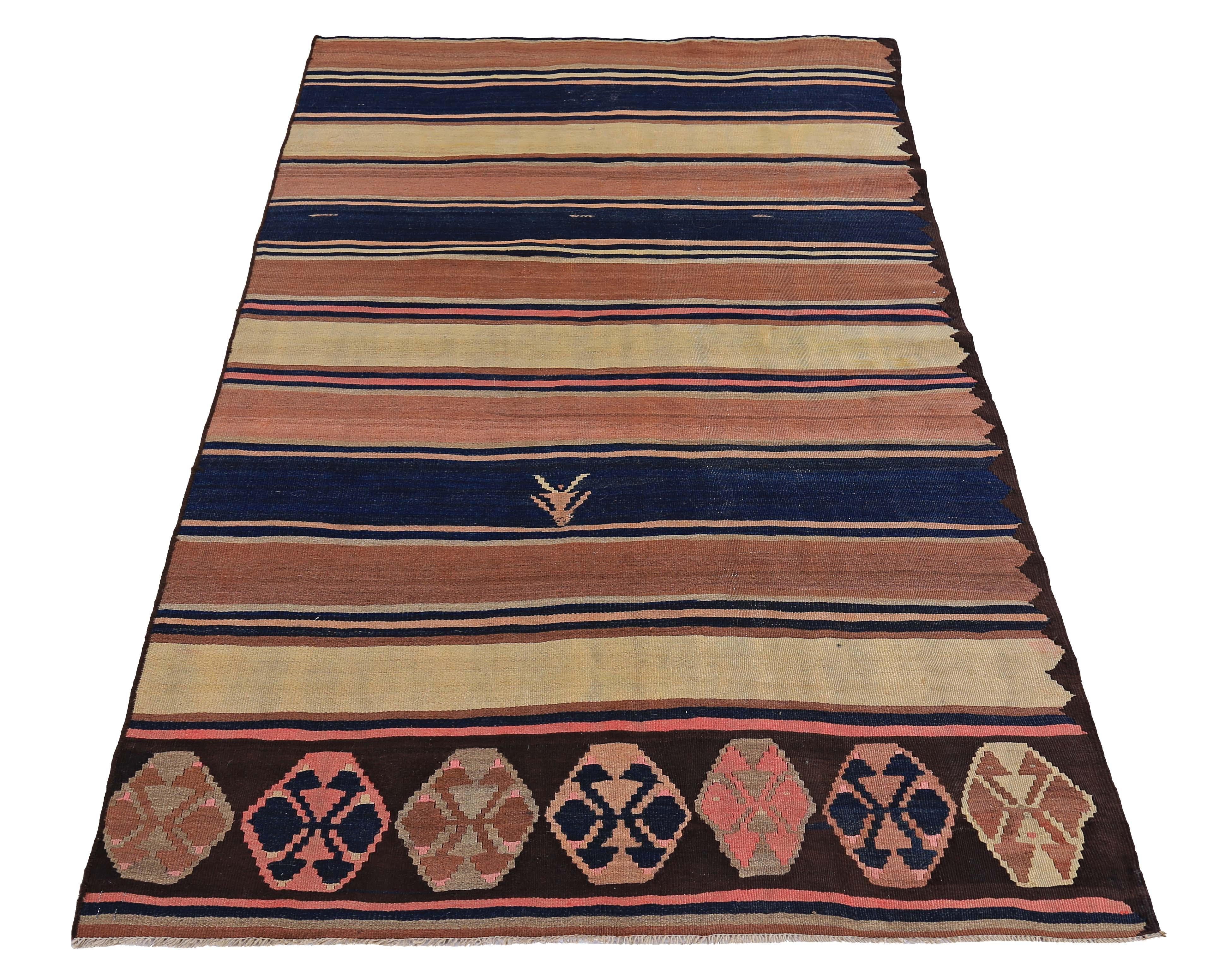 Tappeto turco moderno tessuto a mano con la migliore lana di pecora e colorato con tinture vegetali del tutto naturali e sicure per l'uomo e gli animali domestici. Si tratta di un Kilim tradizionale a trama piatta con strisce marroni, gialle e blu.