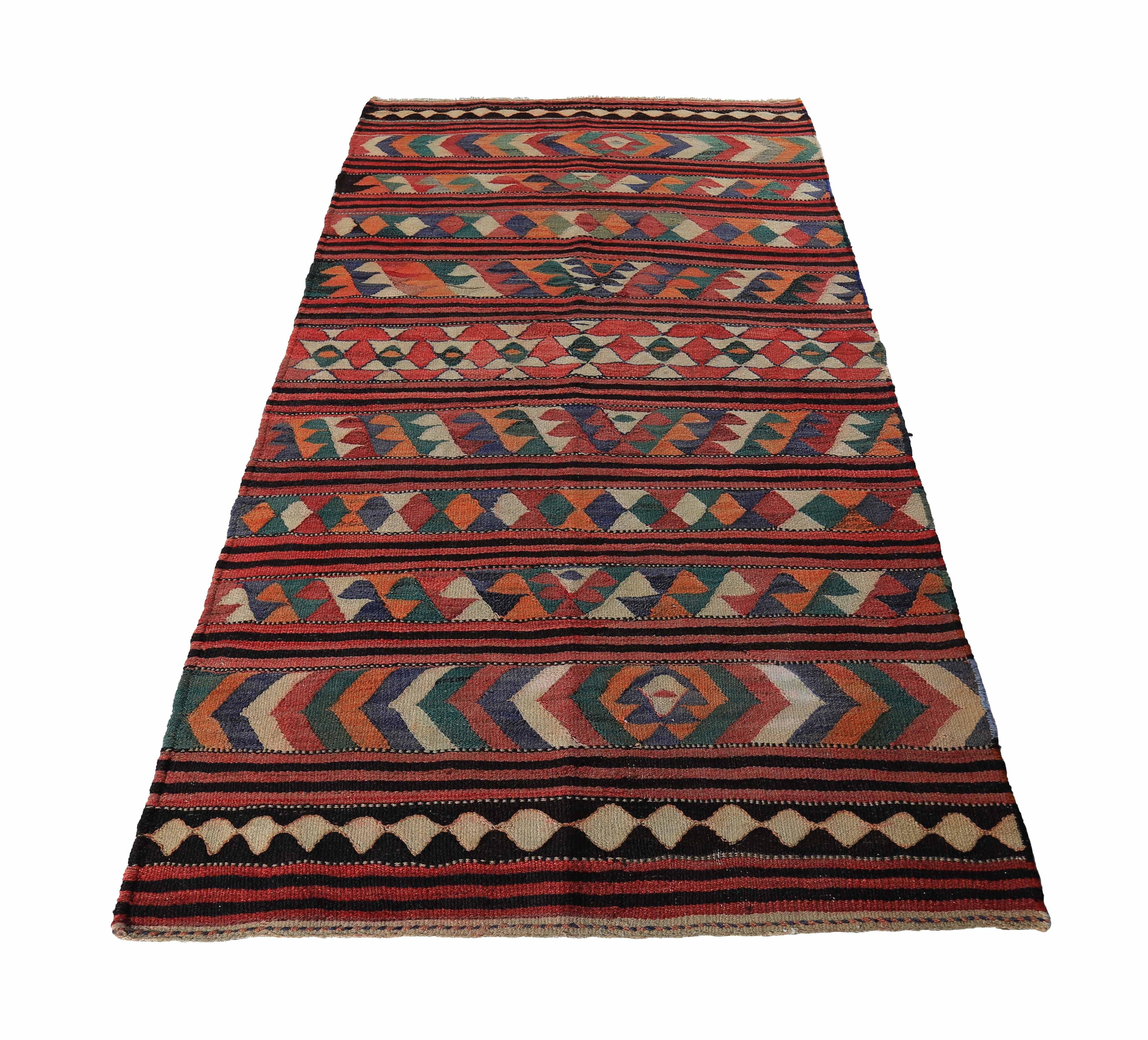 Modern Turkish rug handwoven from the finest sheep’s wool and colored with all-natural vegetable dyes that are safe for humans and pets. It’s a traditional Kilim flat-weave design featuring navy, green, and ivory geometric details on a beautiful red