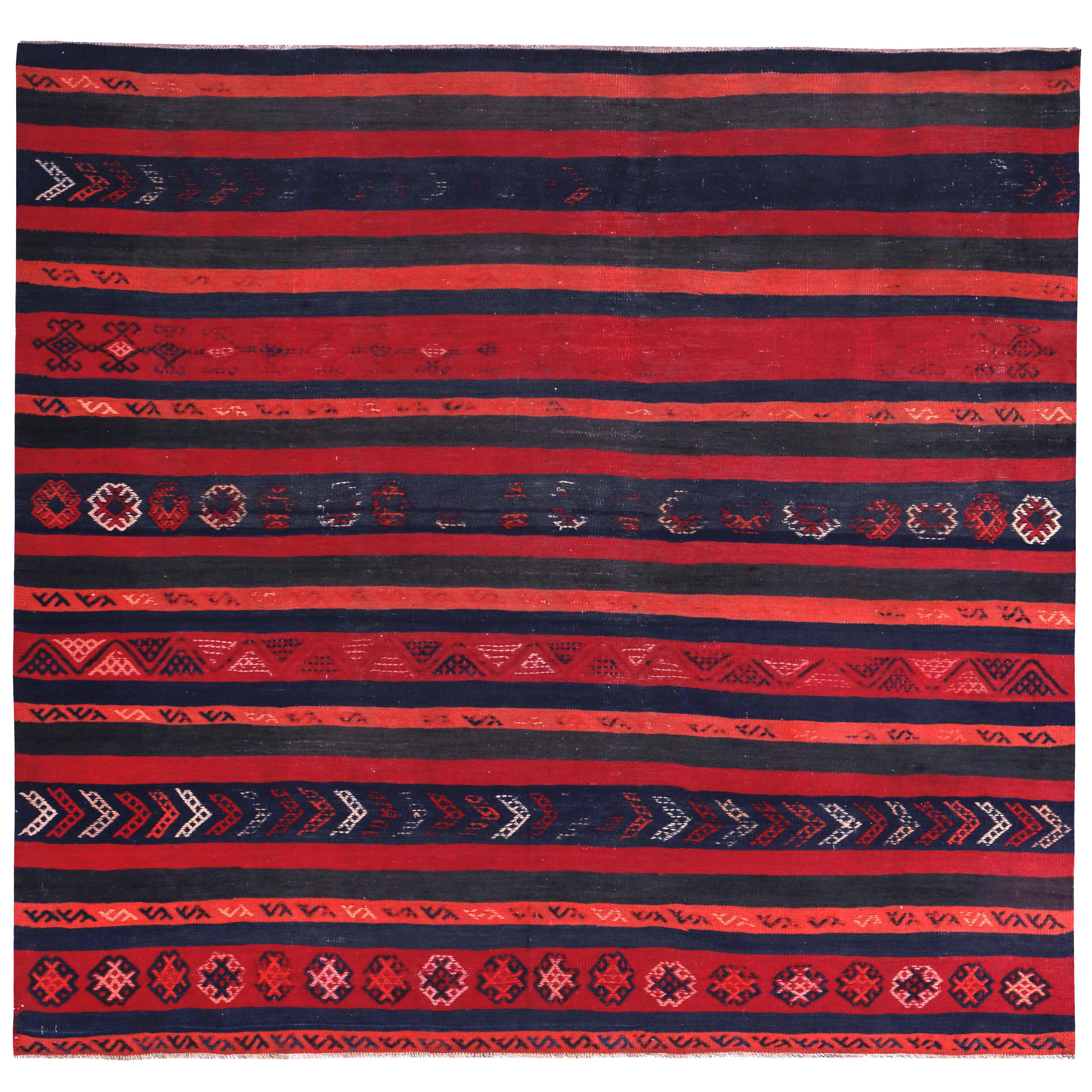 Moderner türkischer Kelim-Teppich mit marineblauem und orangefarbenem Stammesmuster auf rotem Feld