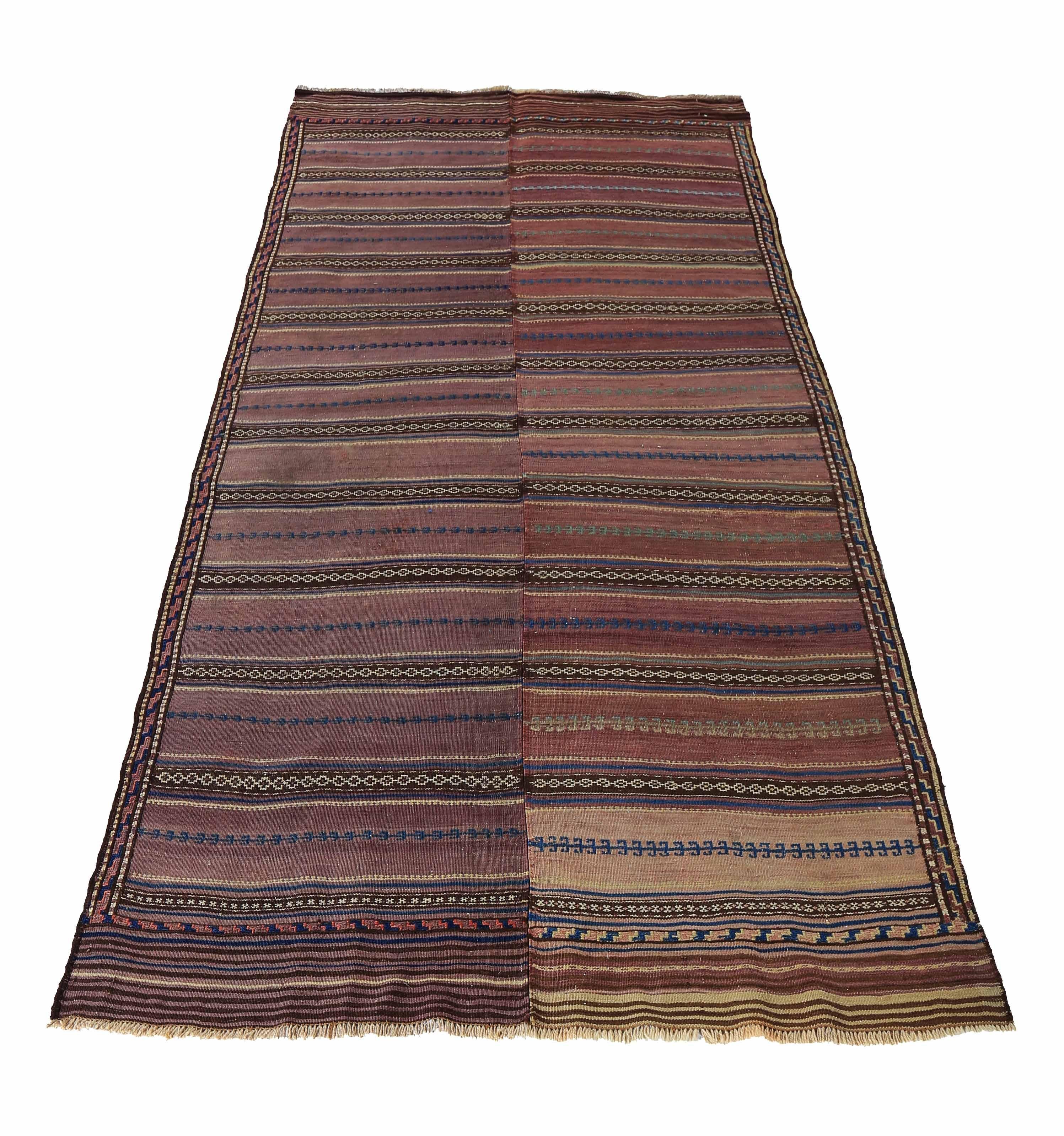 Modern Turkish rug handwoven from the finest sheep’s wool and colored with all-natural vegetable dyes that are safe for humans and pets. It’s a traditional Kilim flat-weave design featuring navy and white tribal details on a brown field. It’s a