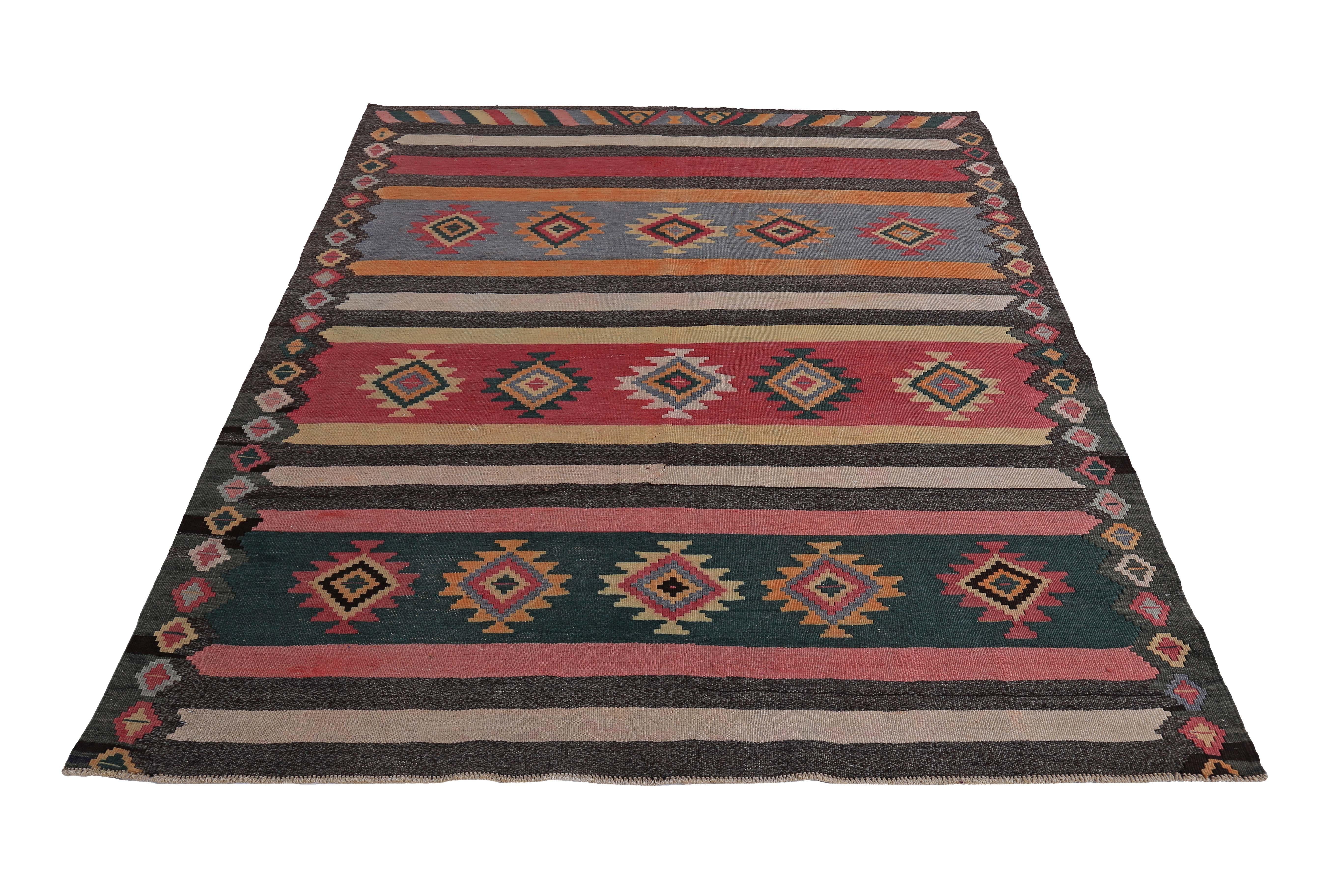 Modern Turkish rug handwoven from the finest sheep’s wool and colored with all-natural vegetable dyes that are safe for humans and pets. It’s a traditional Kilim flat-weave design featuring red, blue, brown and orange with tribal diamonds. It’s a