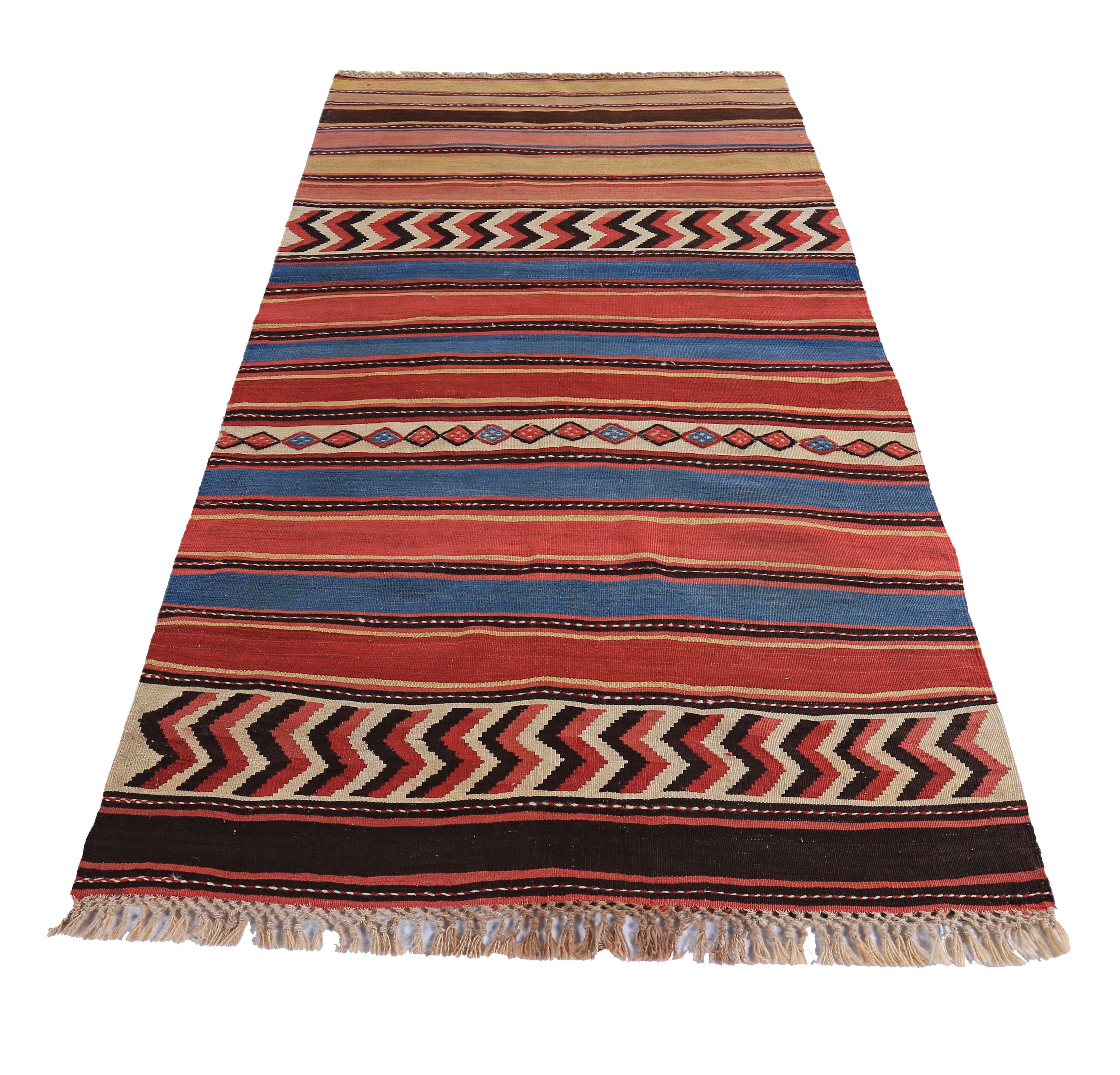 Turkish rug handwoven from the finest sheep’s wool and colored with all-natural vegetable dyes that are safe for humans and pets. It’s a traditional Kilim flat-weave design featuring red and blue tribal design patterns on a beige field. It’s a