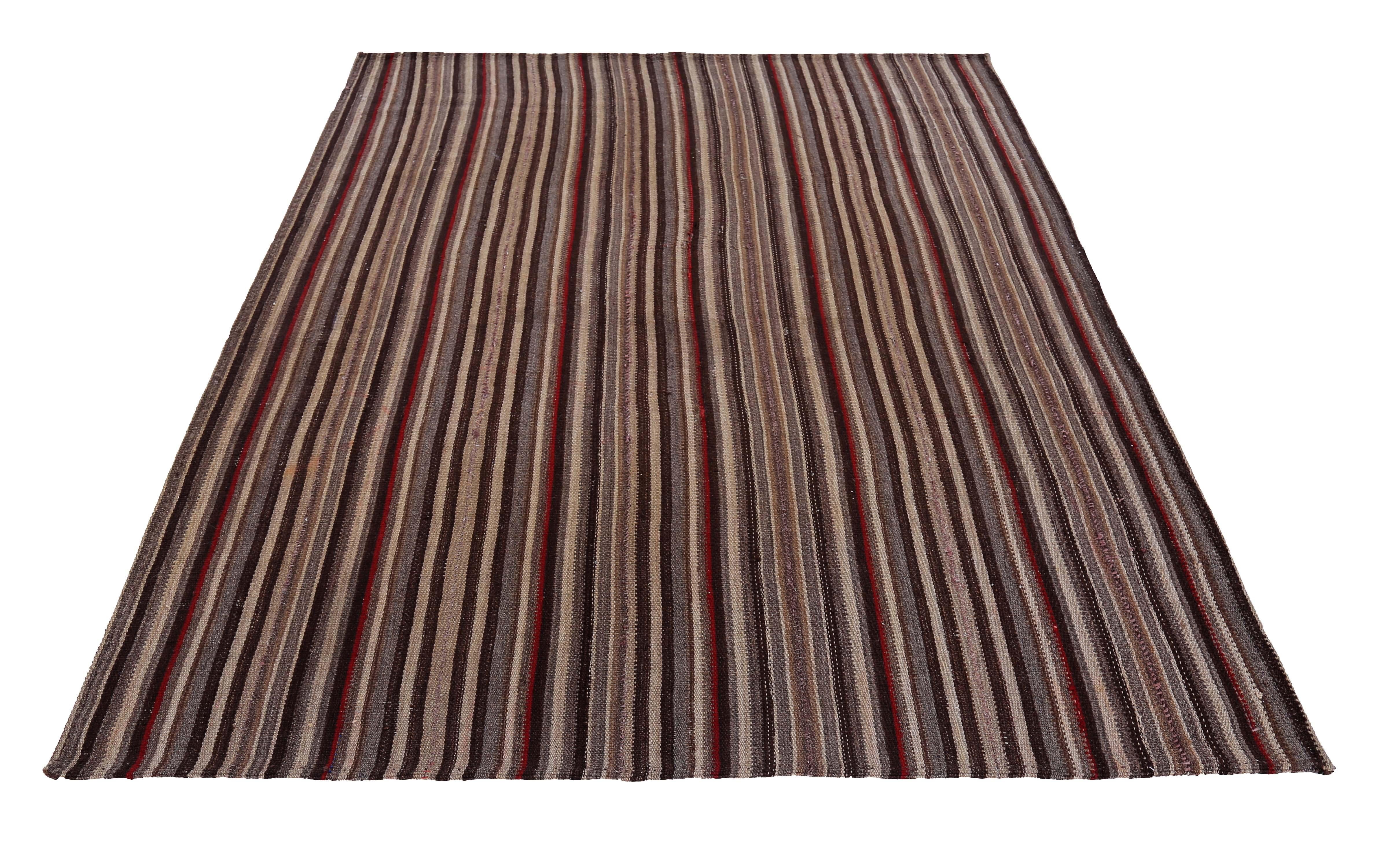 Modern Turkish rug handwoven from the finest sheep’s wool and colored with all-natural vegetable dyes that are safe for humans and pets. It’s a traditional Kilim flat-weave design featuring red, brown and beige stripes. It’s a stunning piece to get