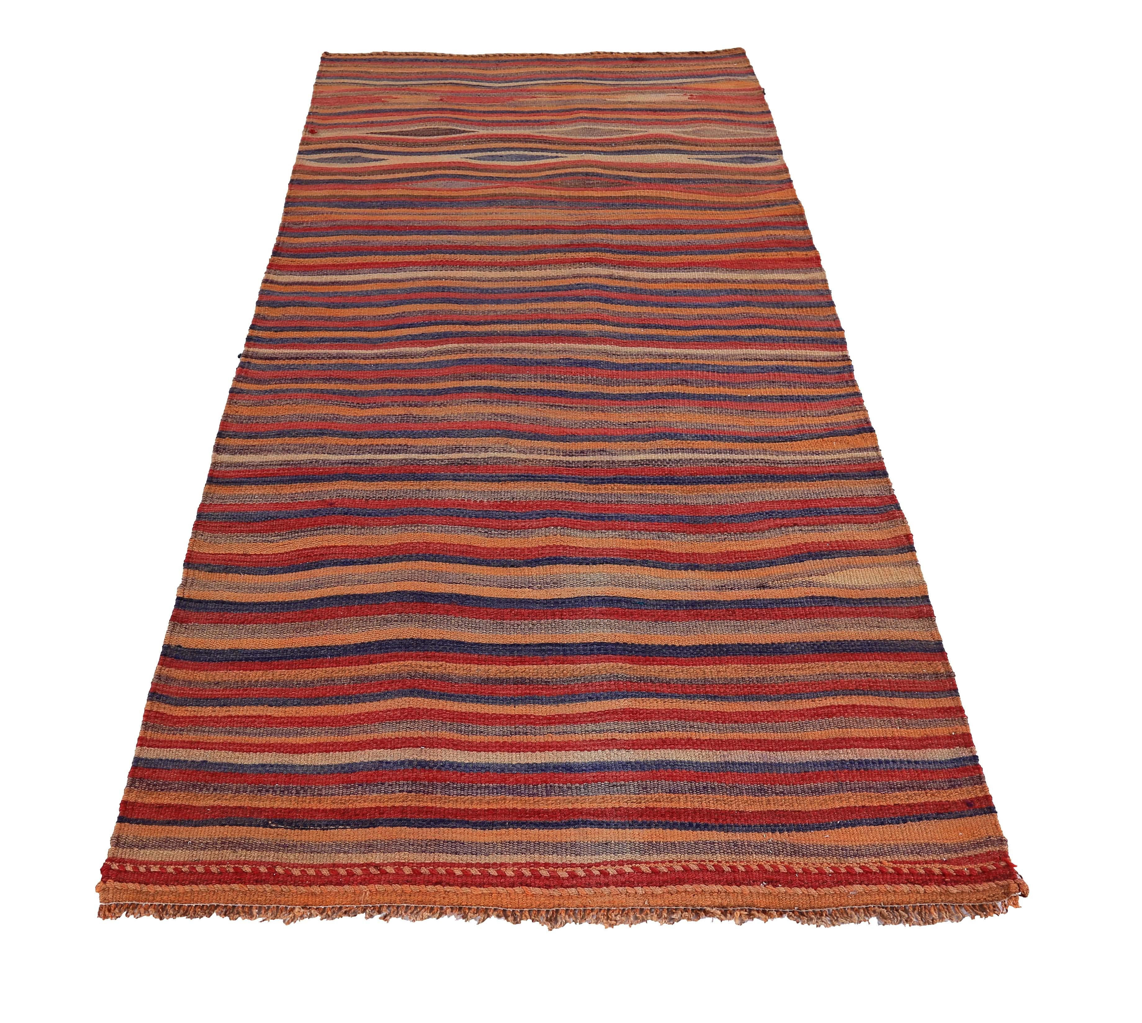 Turkish rug handwoven from the finest sheep’s wool and colored with all-natural vegetable dyes that are safe for humans and pets. It’s a traditional Kilim flat-weave design featuring red, orange and blue stripes. It’s a stunning piece to get for