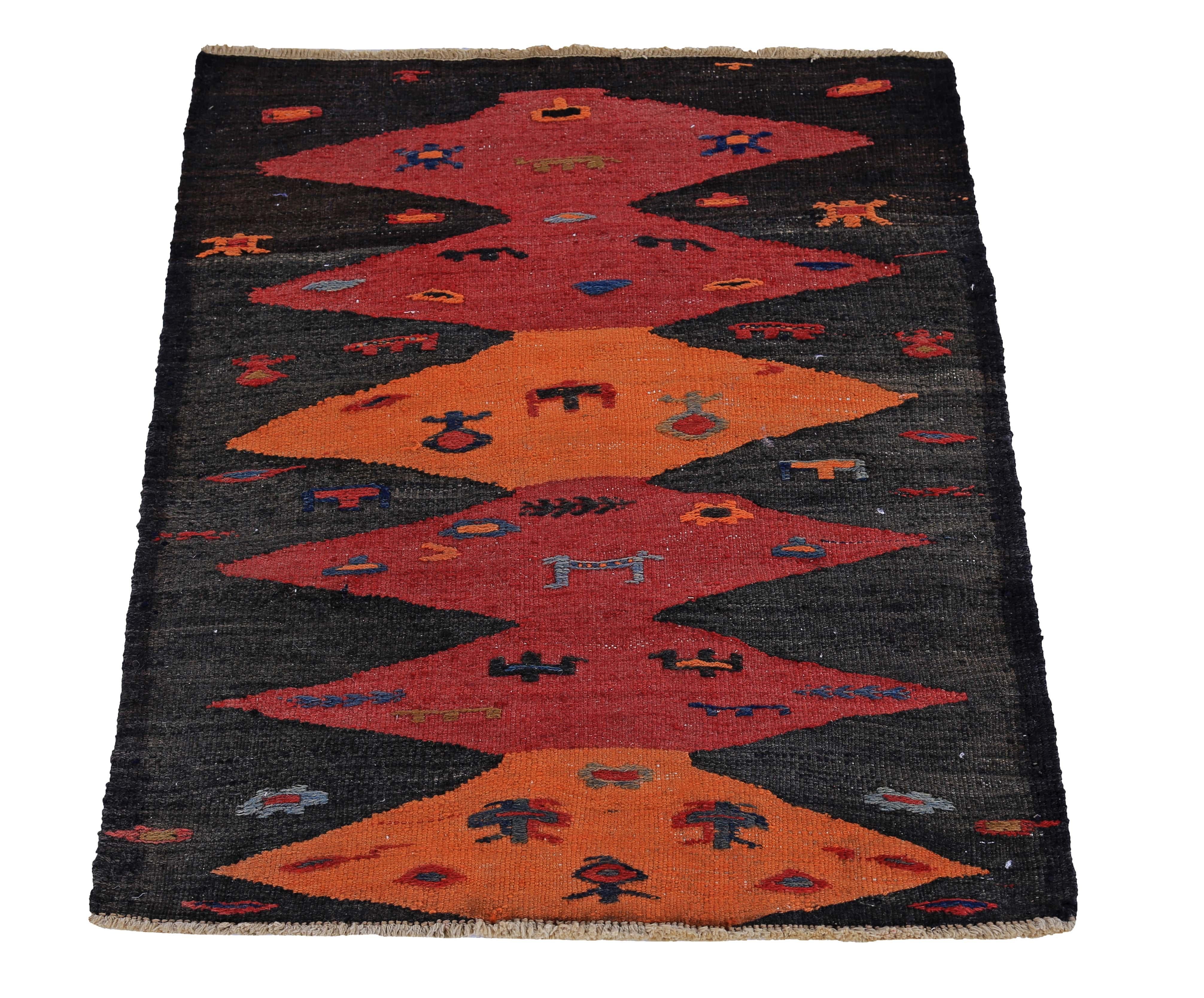 Turkish rug handwoven from the finest sheep’s wool and colored with all-natural vegetable dyes that are safe for humans and pets. It’s a traditional Kilim flat-weave design featuring red and orange diamond patterns in a black field. It’s a stunning