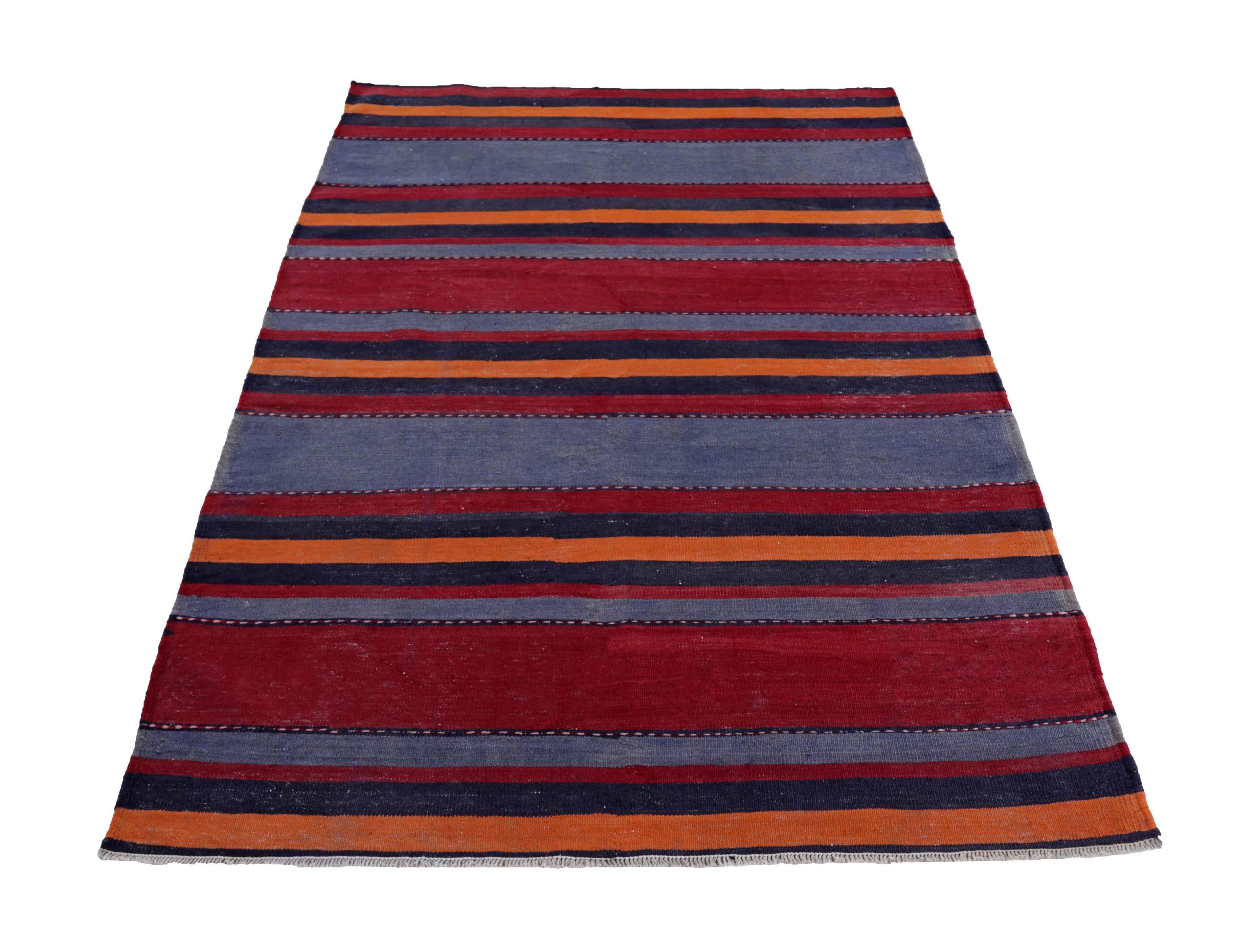 Turkish rug handwoven from the finest sheep’s wool and colored with all-natural vegetable dyes that are safe for humans and pets. It’s a traditional Kilim flat-weave design featuring red and orange stripes in a Navy field. It’s a stunning piece to