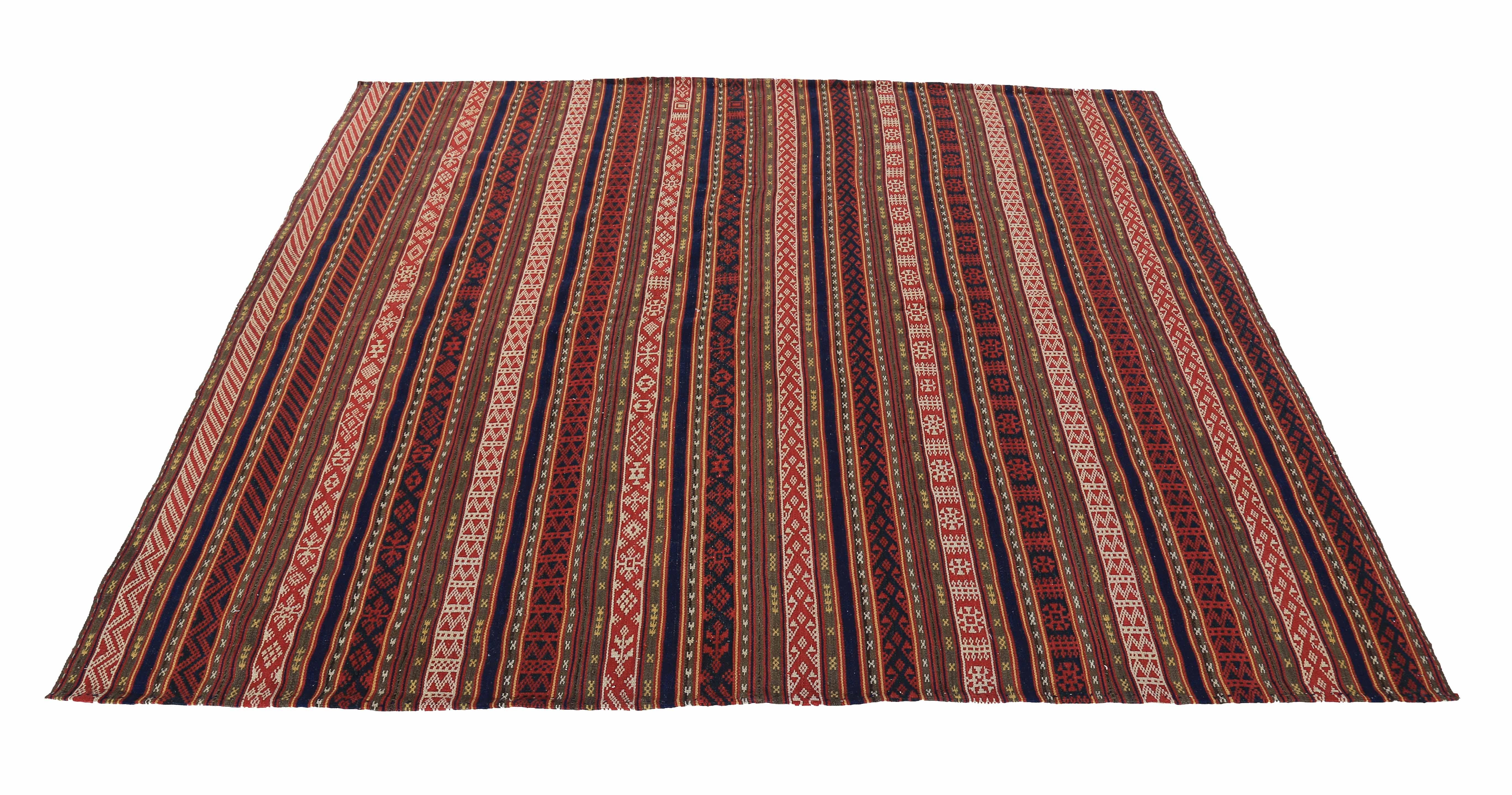 Modern Turkish rug handwoven from the finest sheep’s wool and colored with all-natural vegetable dyes that are safe for humans and pets. It’s a traditional Kilim flat-weave design featuring red and white tribal details on a striped field. It’s a