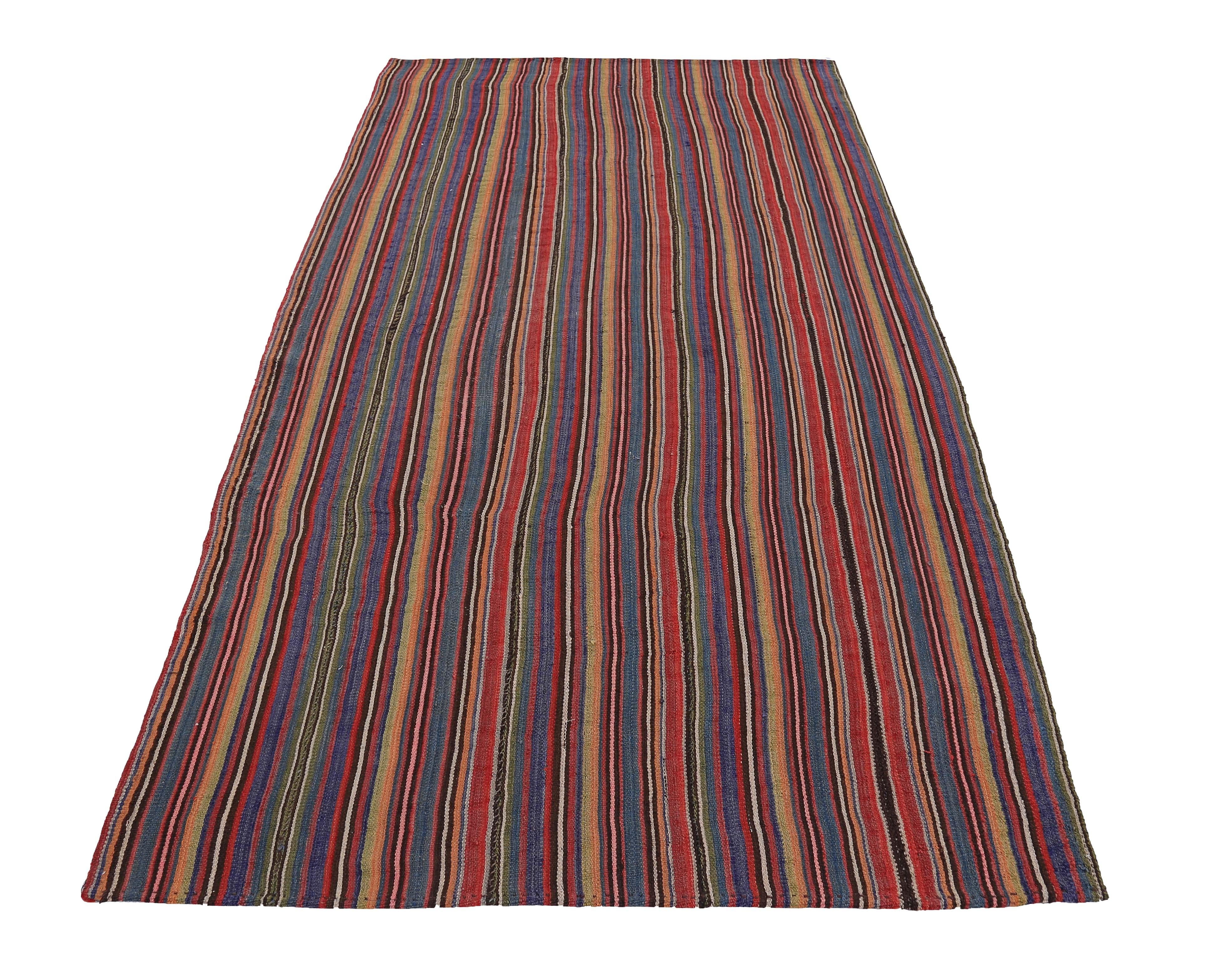Turkish Kilim rug handwoven from the finest sheep’s wool and colored with all-natural vegetable dyes that are safe for humans and pets. It’s a traditional Kilim flat-weave design featuring red, yellow and blue pencil stripes. It’s a stunning piece