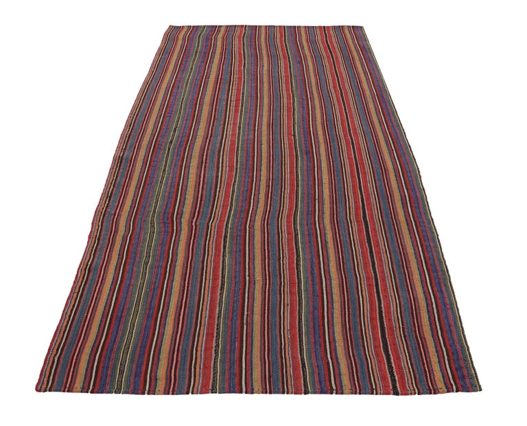 Turkish Kilim rug handwoven from the finest sheep’s wool and colored with all-natural vegetable dyes that are safe for humans and pets. It’s a traditional Kilim flat-weave design featuring red, yellow and blue pencil stripes. It’s a stunning piece