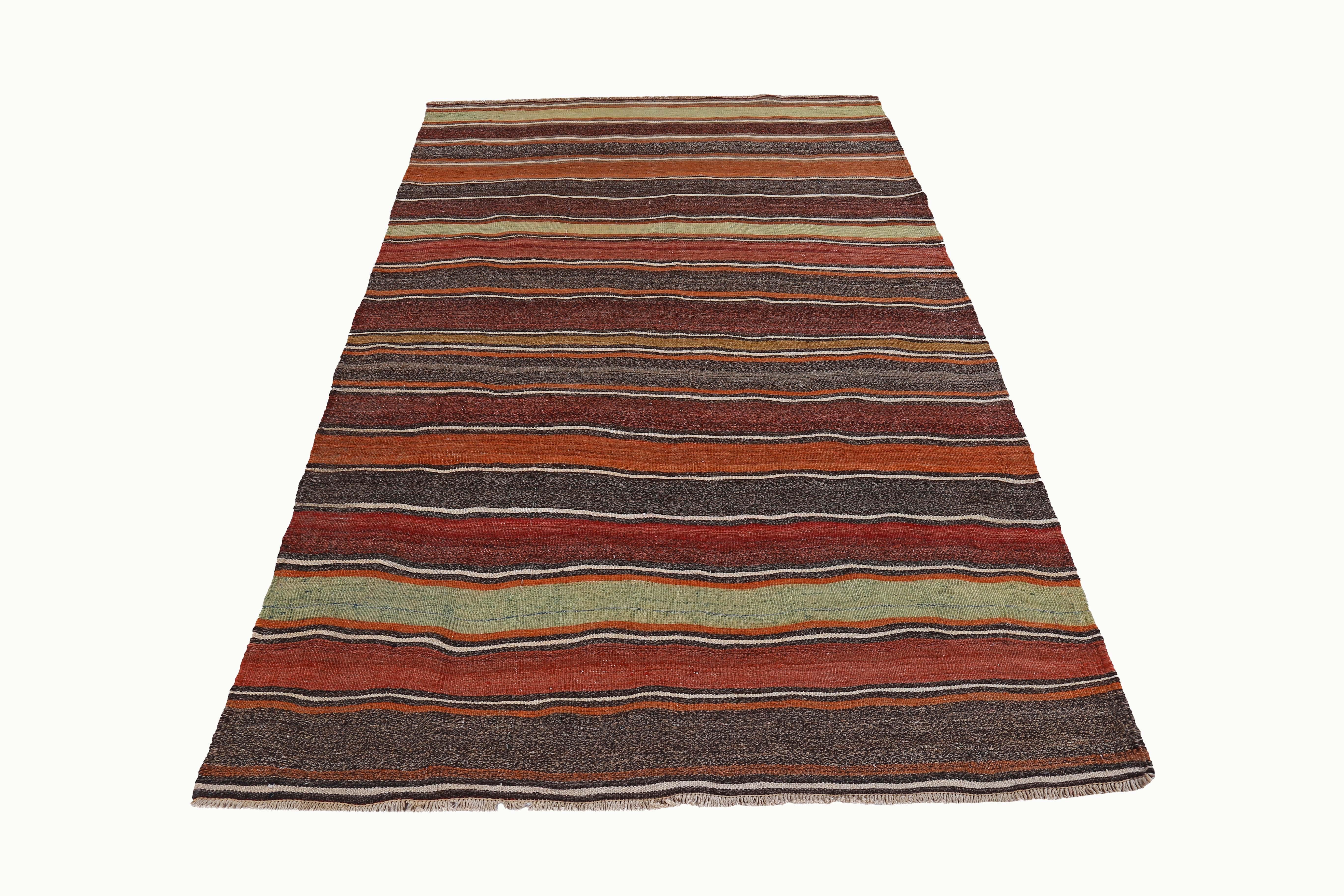 Turkish Kilim rug handwoven from the finest sheep’s wool and colored with all-natural vegetable dyes that are safe for humans and pets. It’s a traditional Kilim flat-weave design featuring red, yellow and orange stripes on a brown field. It’s a