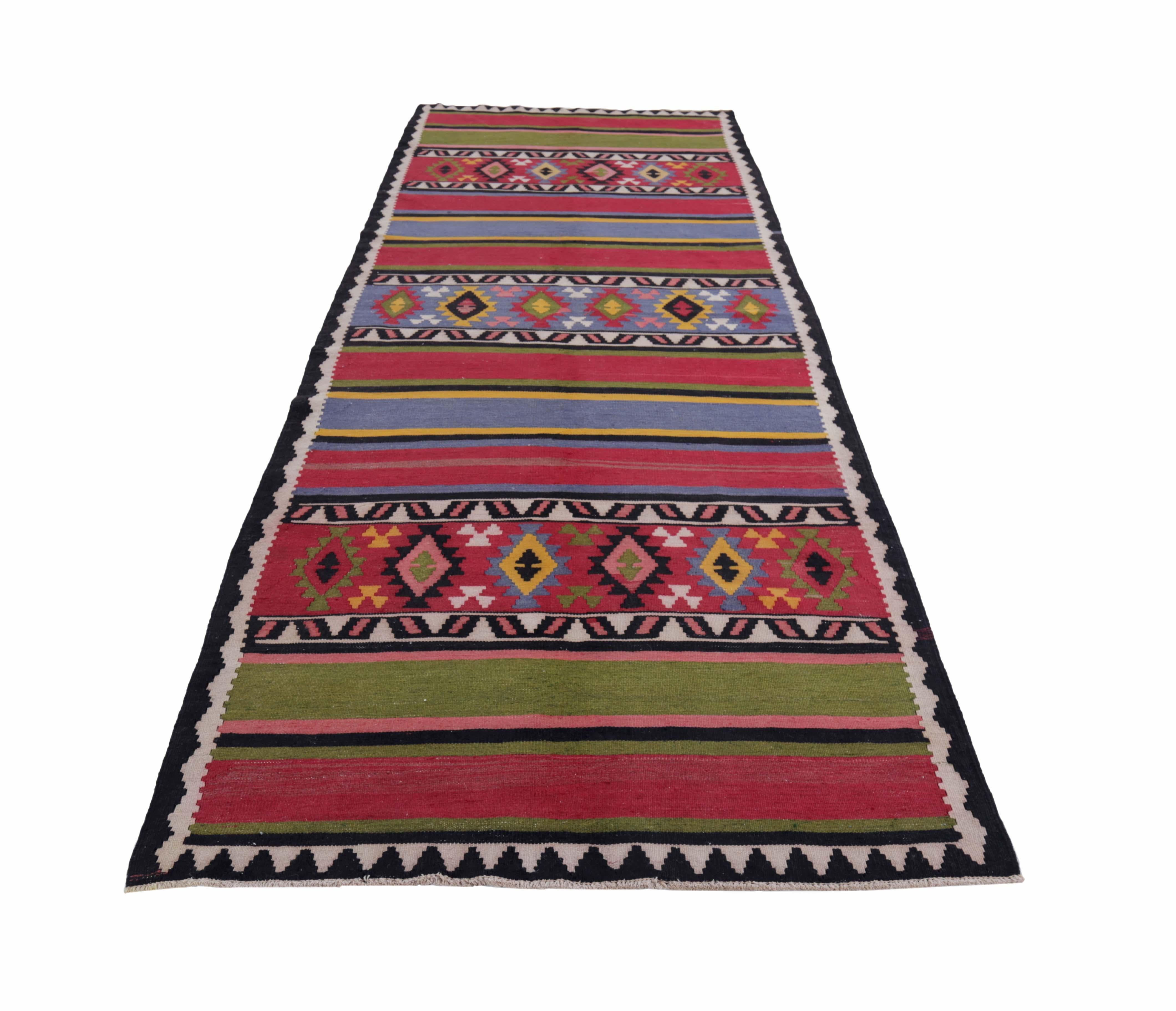 Turkish rug handwoven from the finest sheep’s wool and colored with all-natural vegetable dyes that are safe for humans and pets. It’s a traditional Kilim flat-weave design featuring red, green and blue stripes with tribal designs. It’s a stunning