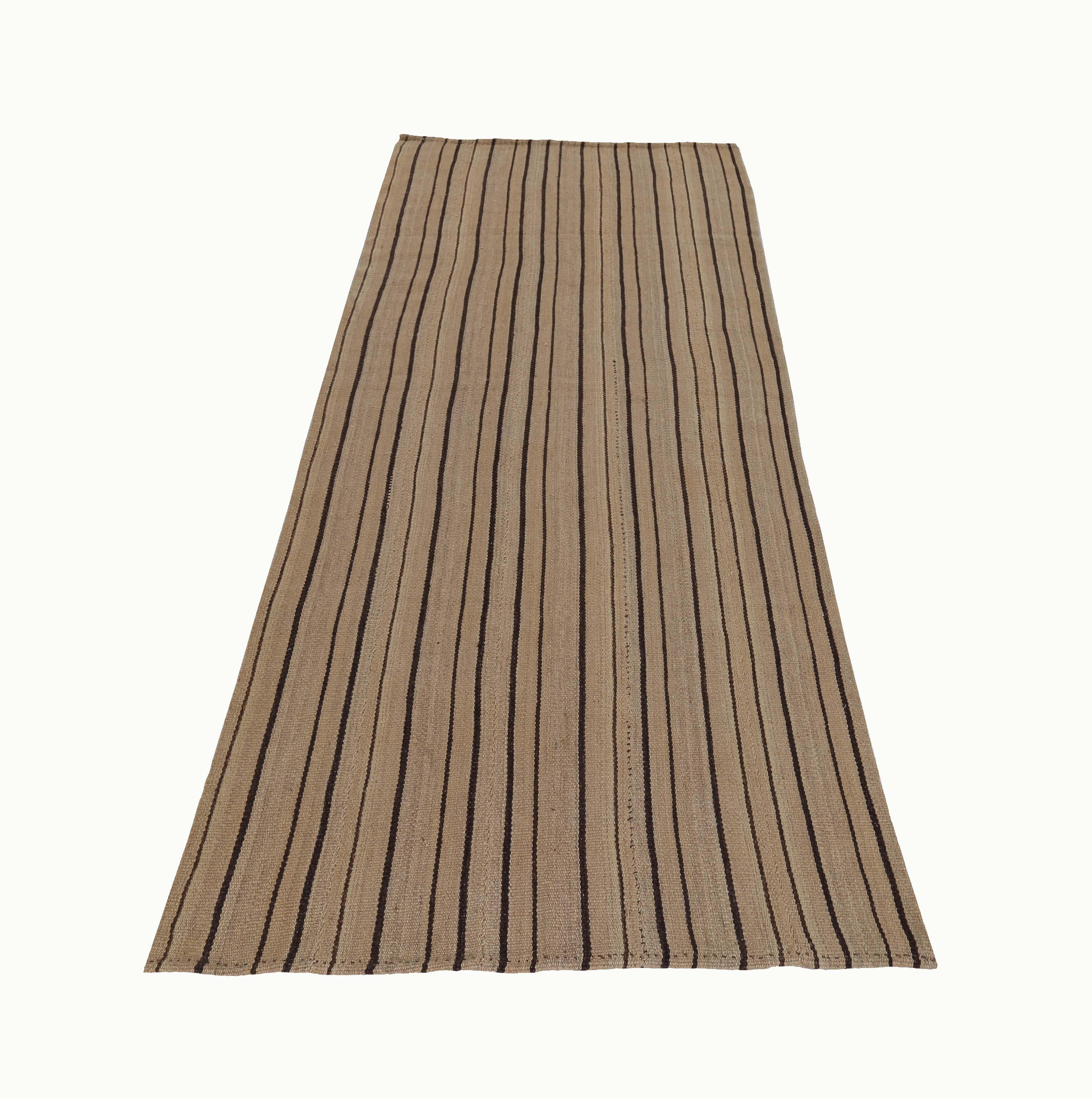 Turkish rug handwoven from the finest sheep’s wool and colored with all-natural vegetable dyes that are safe for humans and pets. It’s a traditional Kilim flat-weave design featuring black pencil stripes on a beige field. It’s a stunning piece to