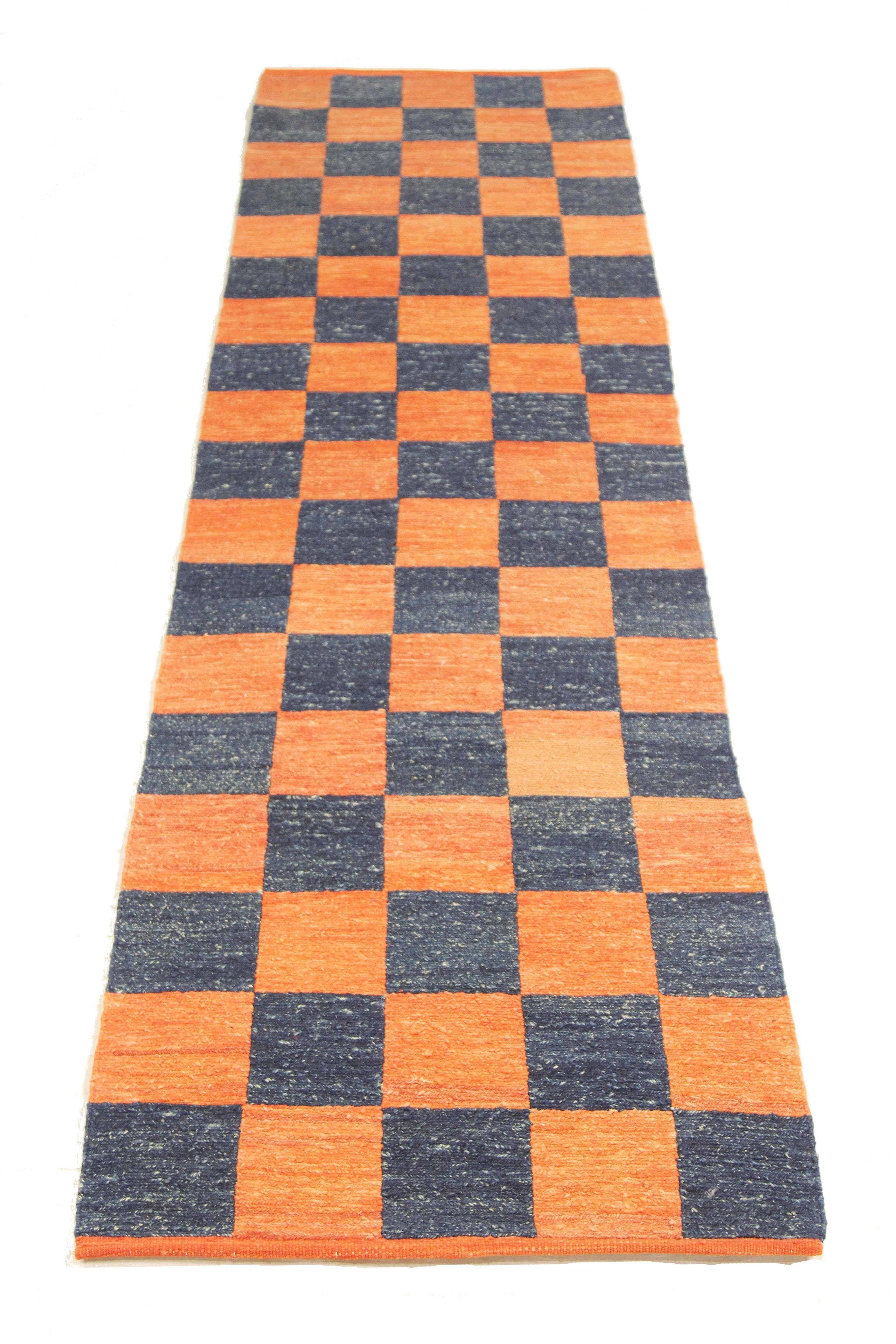 Turkish rug handwoven from the finest sheep’s wool and colored with all-natural vegetable dyes that are safe for humans and pets. It’s a traditional Kilim flat-weave design featuring navy blue tile patterns on a plush orange field. It’s a stunning