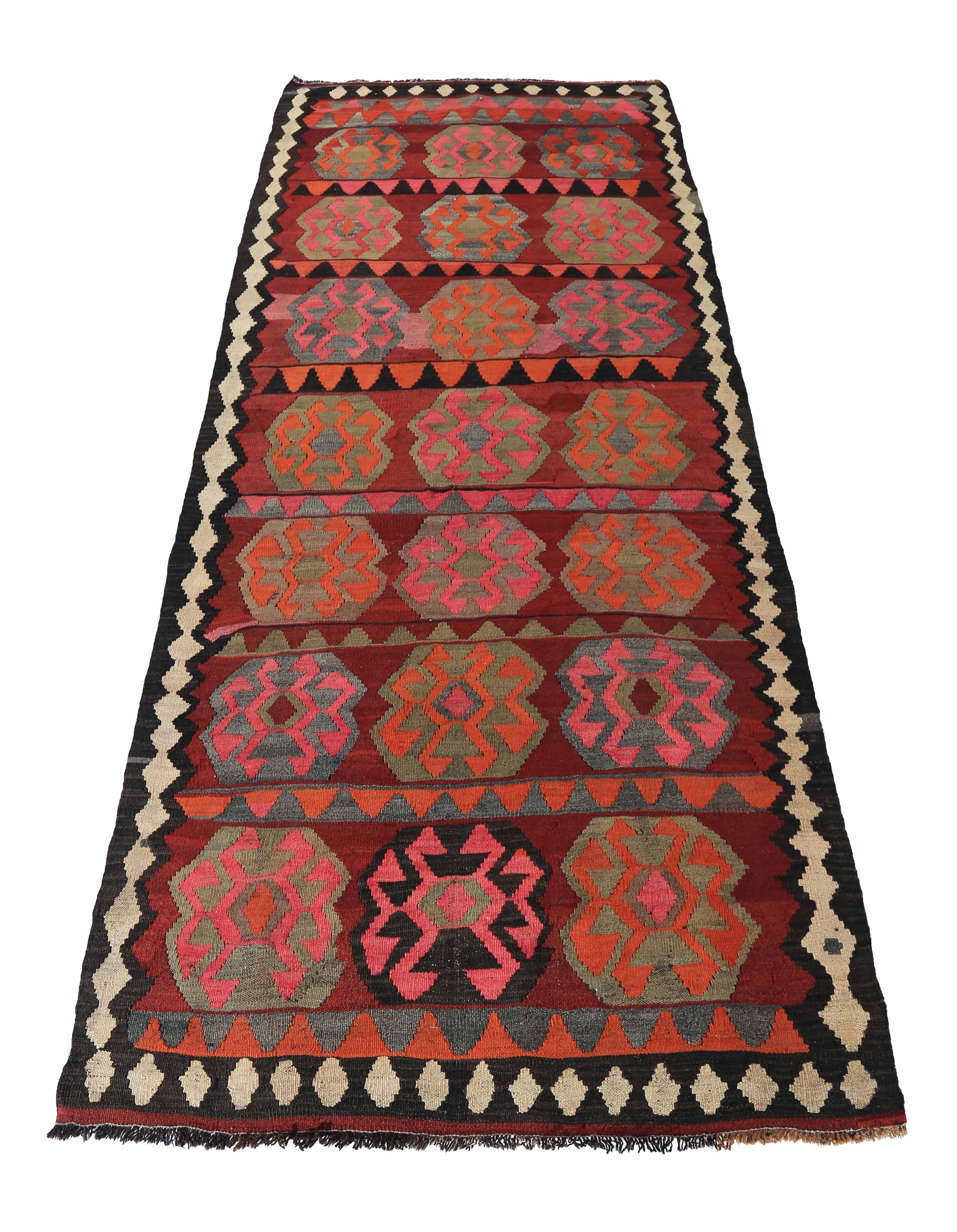 Modern Turkish rug handwoven from the finest sheep’s wool and colored with all-natural vegetable dyes that are safe for humans and pets. It’s a traditional Kilim flat-weave design featuring orange, pink and red tribal medallions. It’s a stunning
