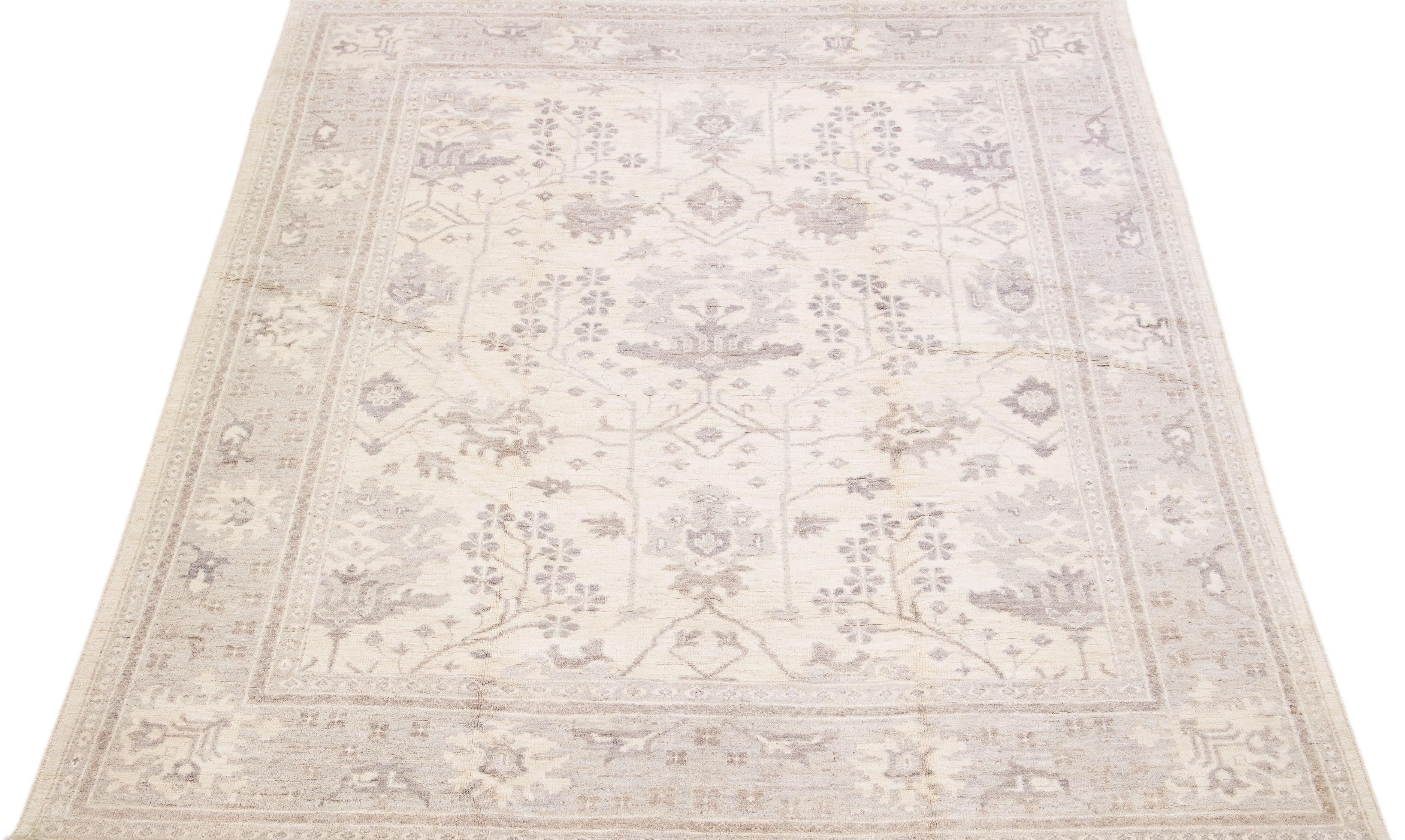 Beautiful modern Oushak hand-knotted wool rug with a beige color field. This Turkish Piece has gray accent colors in a gorgeous all-over floral design.

This rug measures: 7'10
