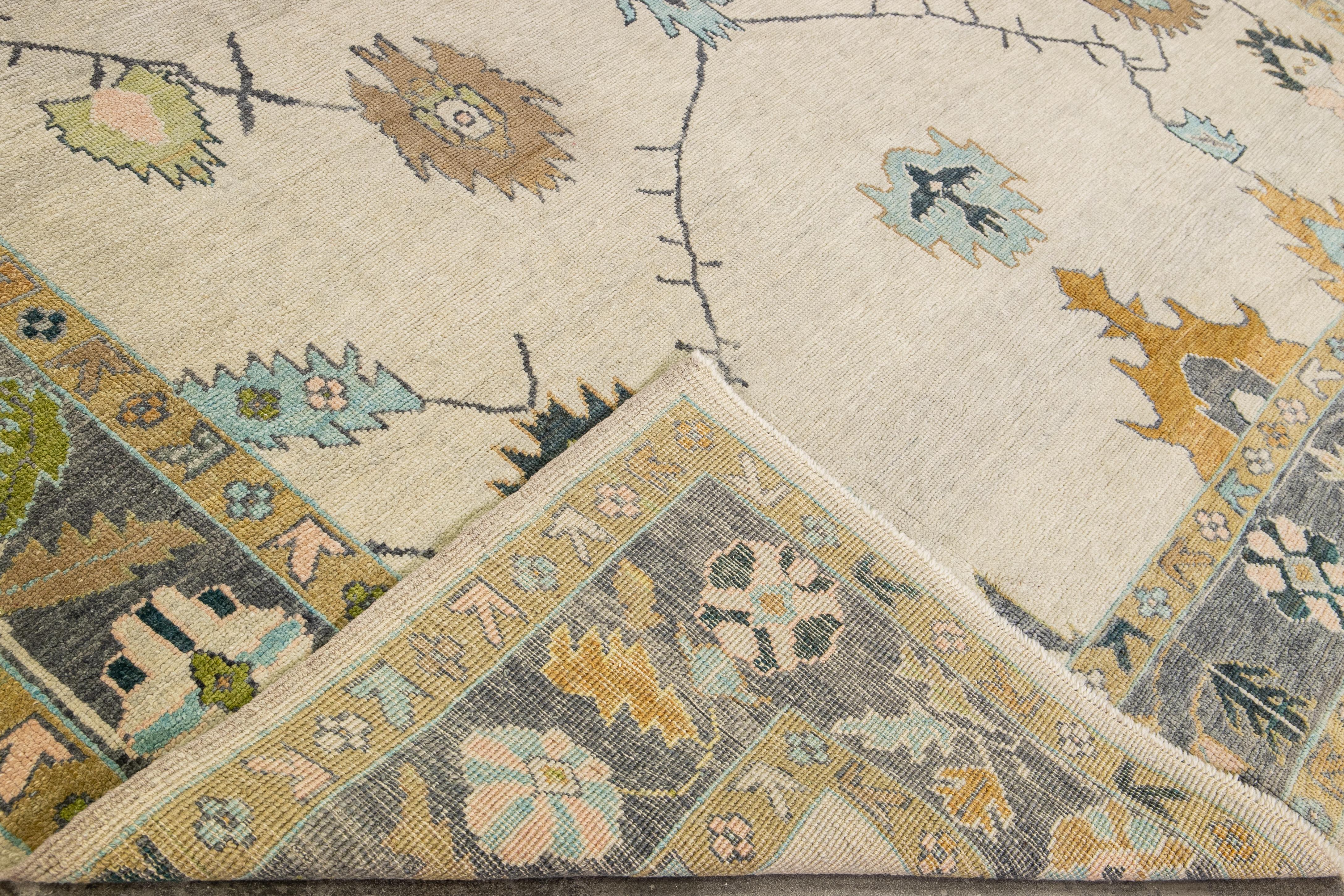 Beautiful modern Oushak hand-knotted wool rug with a beige field. This Oushak rug has a gray frame and multi-color accents all over a gorgeous geometric floral design.

This rug measures 9'10