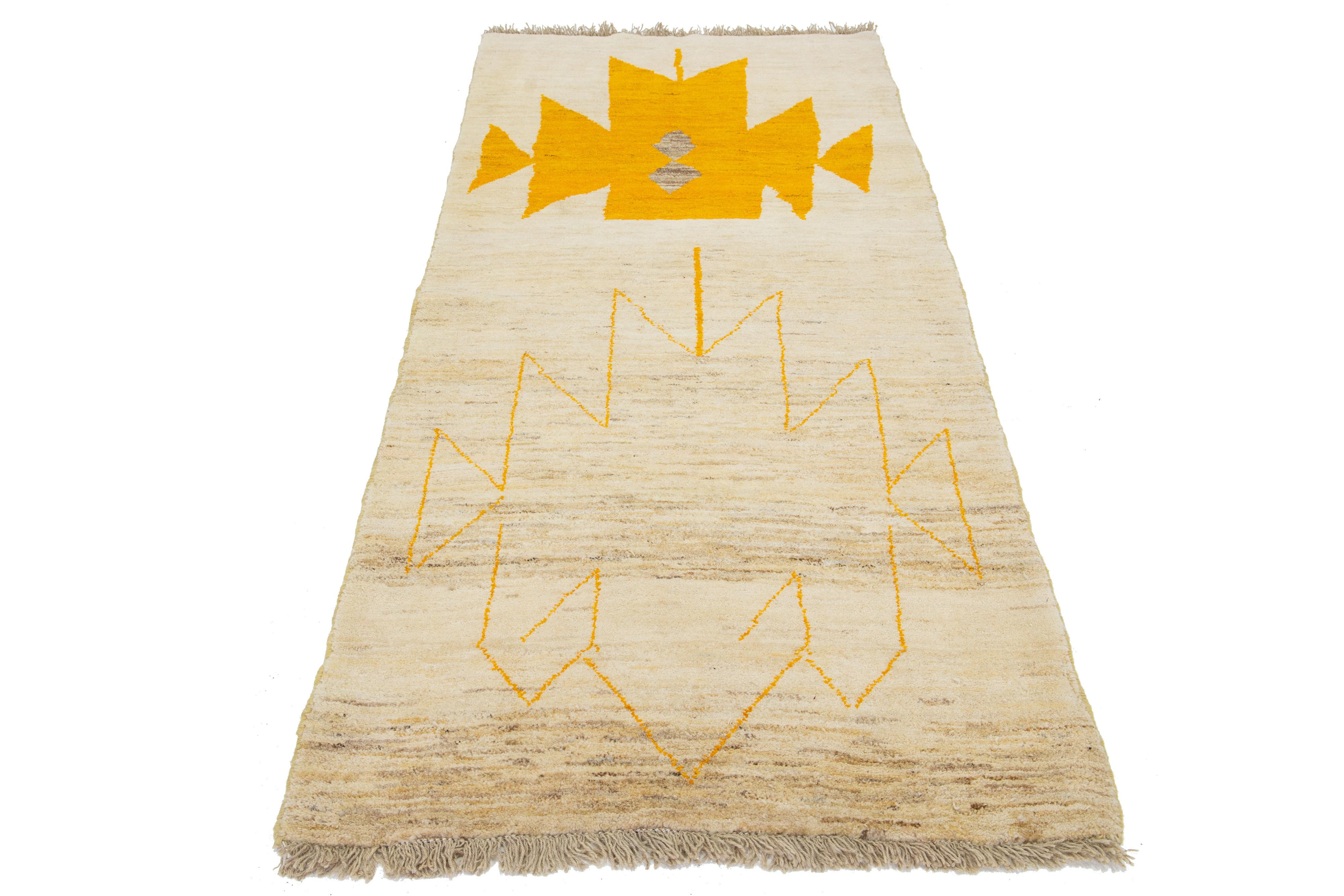 This hand-knotted wool rug features a lovely beige base and a stunning geometric pattern with vibrant orange and gray accents. It's an exquisite addition to any decor.

This rug measures 3'5