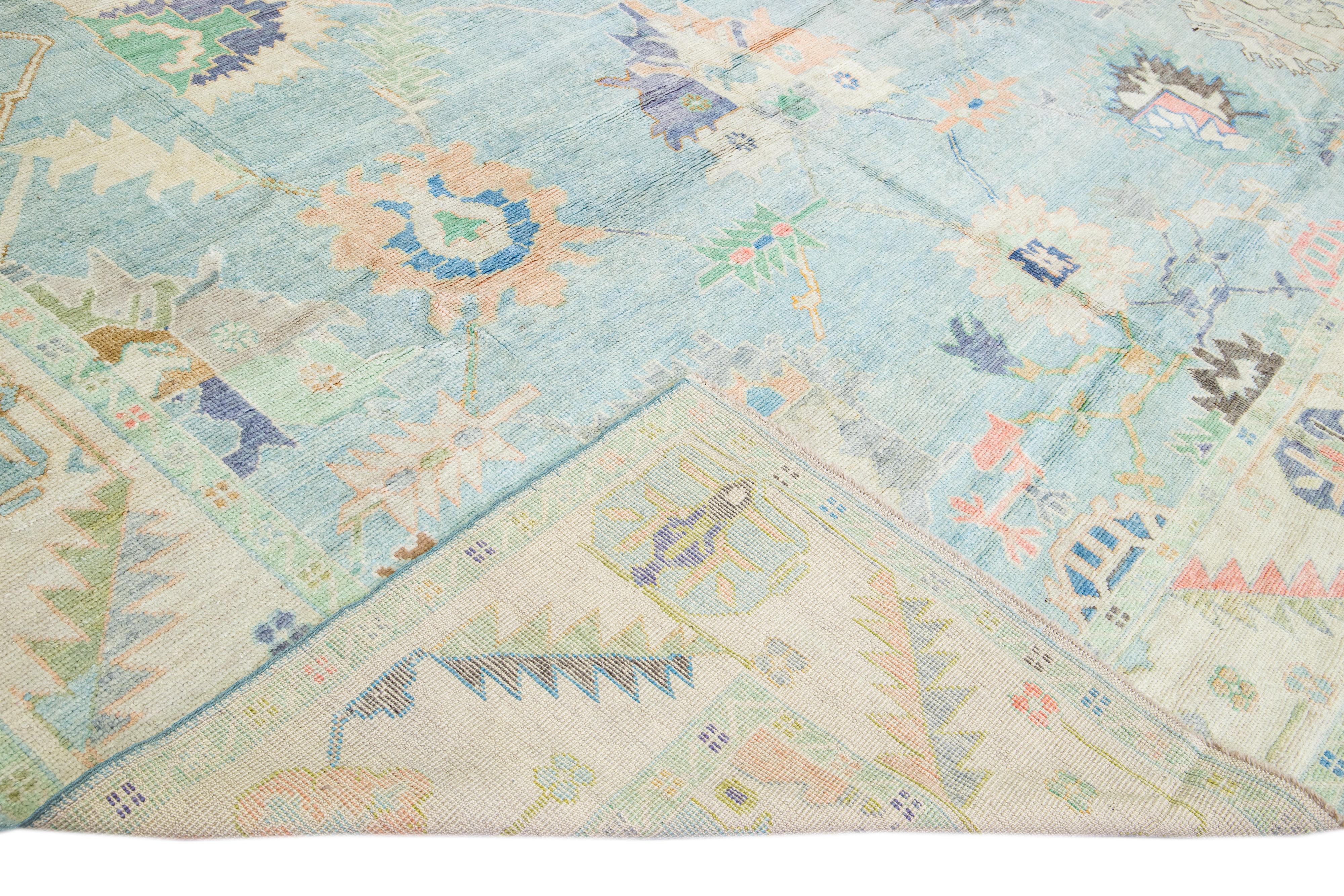 Beautiful modern Oushak hand-knotted wool rug with a blue field. This Oushak rug has beige frame multicolor accents that feature a gorgeous geometric floral pattern design. 

This rug measures: 12'2