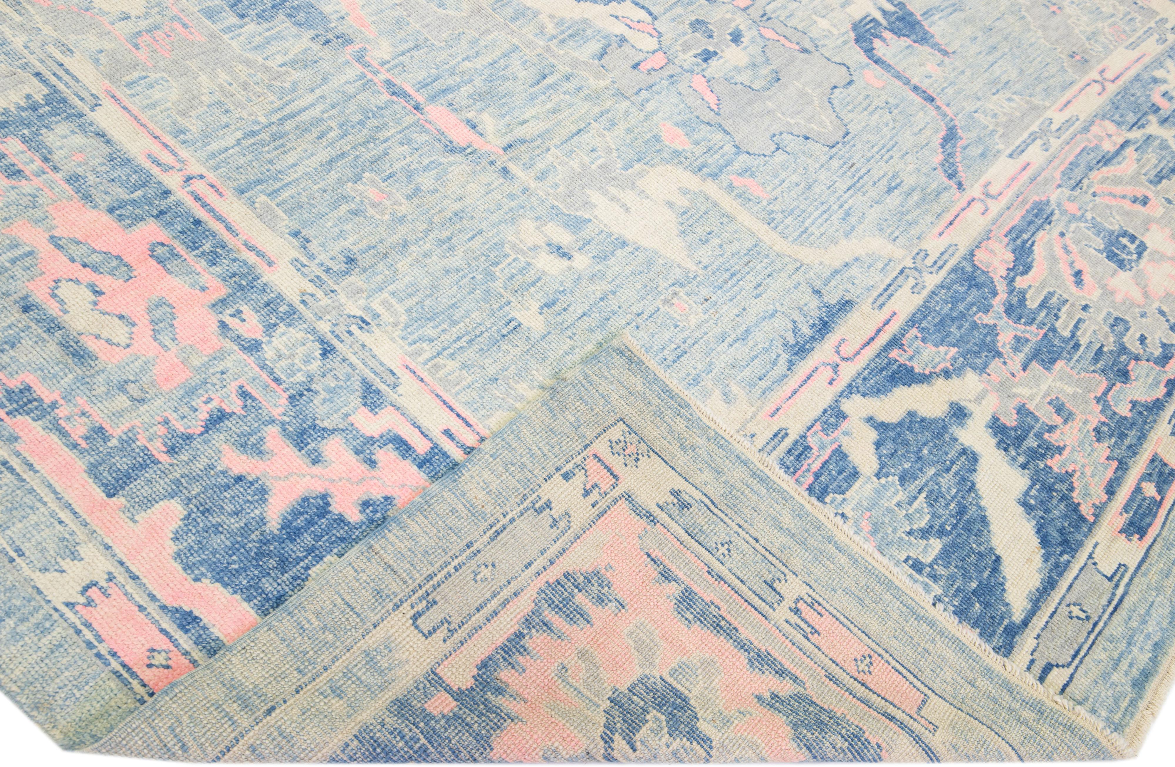 Schöner moderner Oushak-Teppich aus handgeknüpfter Wolle mit blauem Farbfeld. Dieses türkische Stück hat eine rosa Akzentfarbe in einem wunderschönen floralen All-Over-Design.

Dieser Teppich misst: 10'1