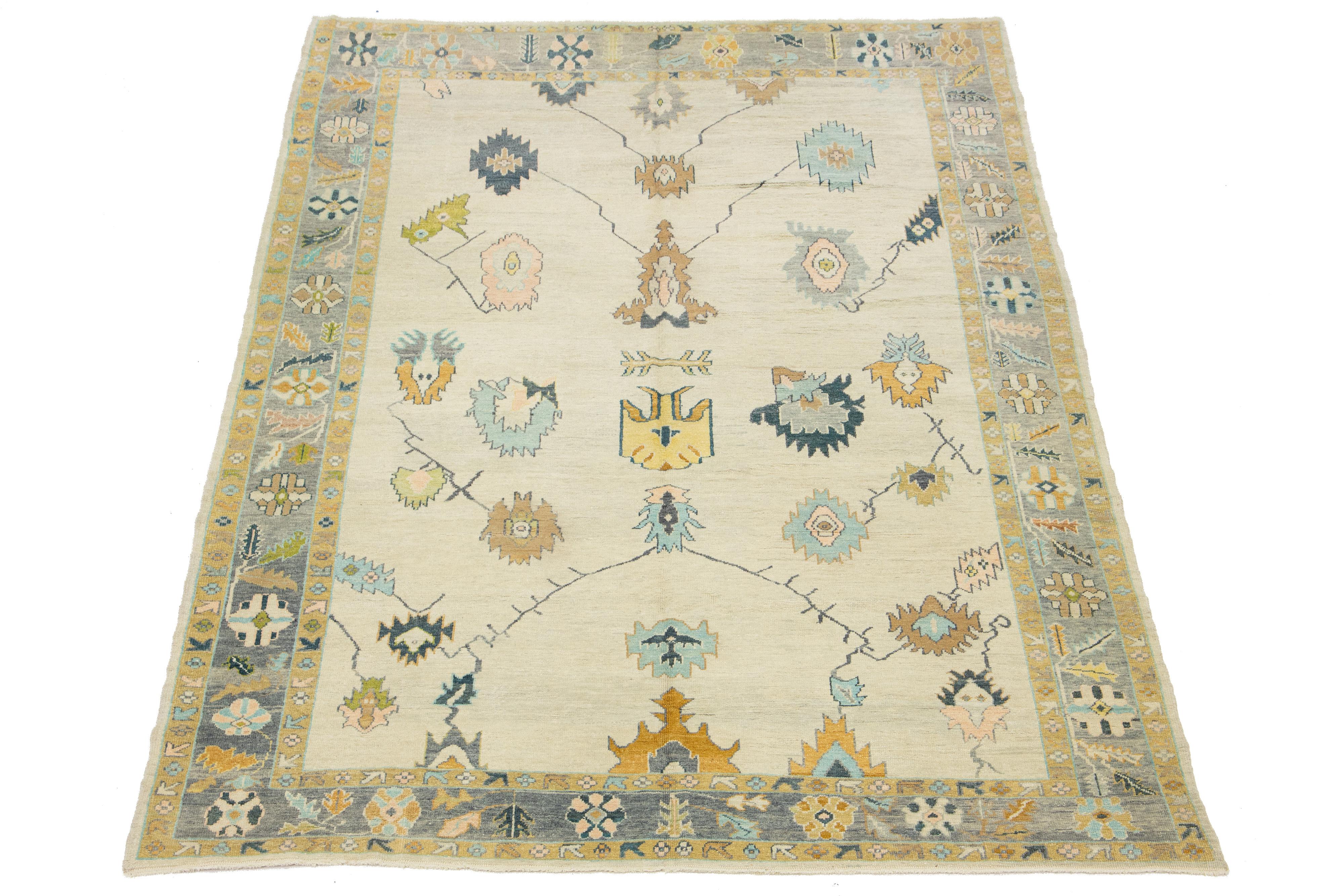 Dieser handgeknüpfte Wollteppich ist ein zeitgenössisches türkisches Stück mit einem beigen Hintergrund und einem attraktiven Allover-Muster aus grauen, orangefarbenen und pfirsichfarbenen Blumenmustern.

Dieser Teppich misst 9'10