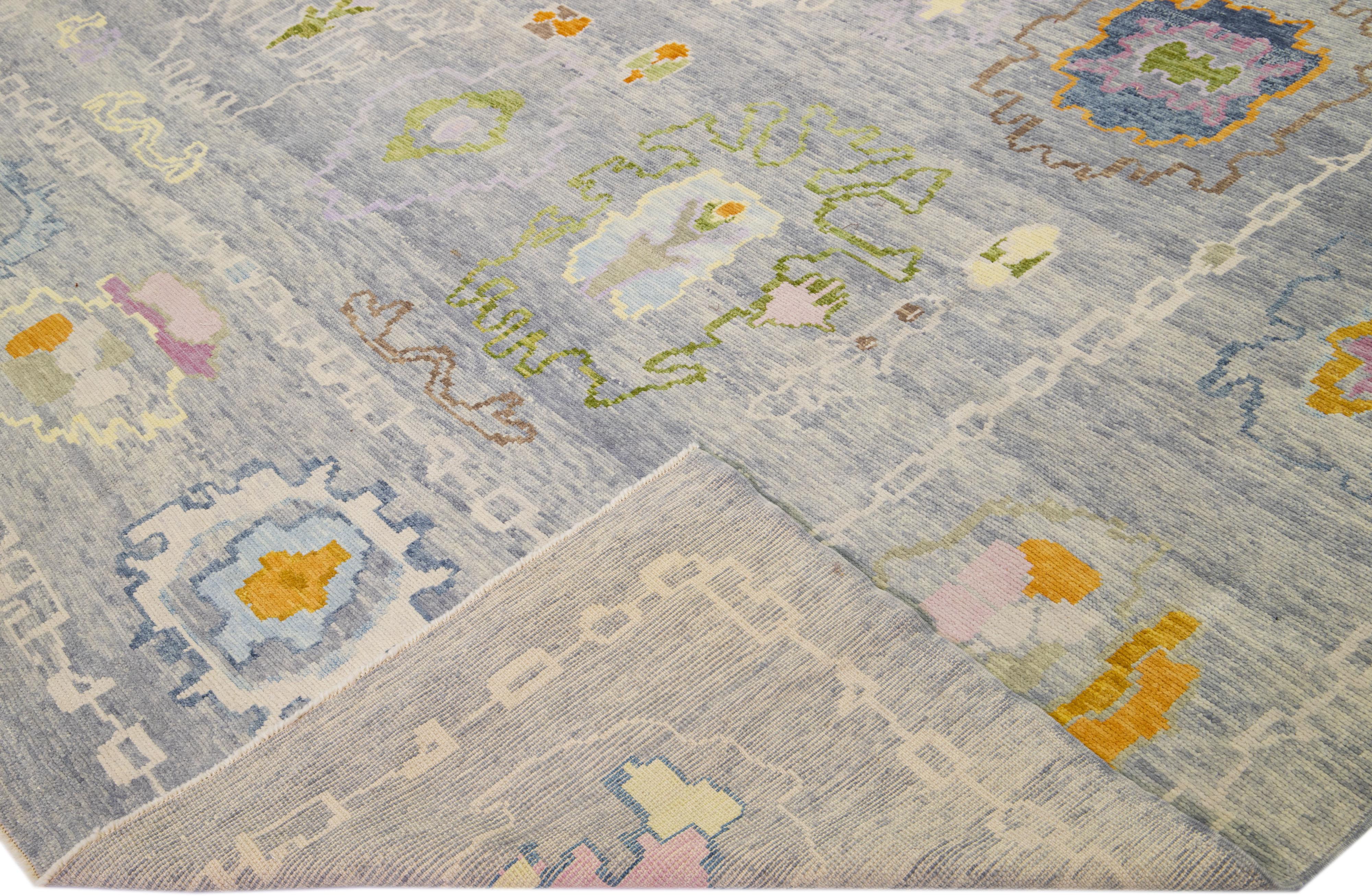 Schöner moderner Oushak-Teppich aus handgeknüpfter Wolle mit einem hellgrauen Farbfeld. Dieses türkische Stück hat gelbe, orange und grüne Akzentfarben in einem wunderschönen floralen All-Over-Design.

Dieser Teppich misst: 12' x 14'10