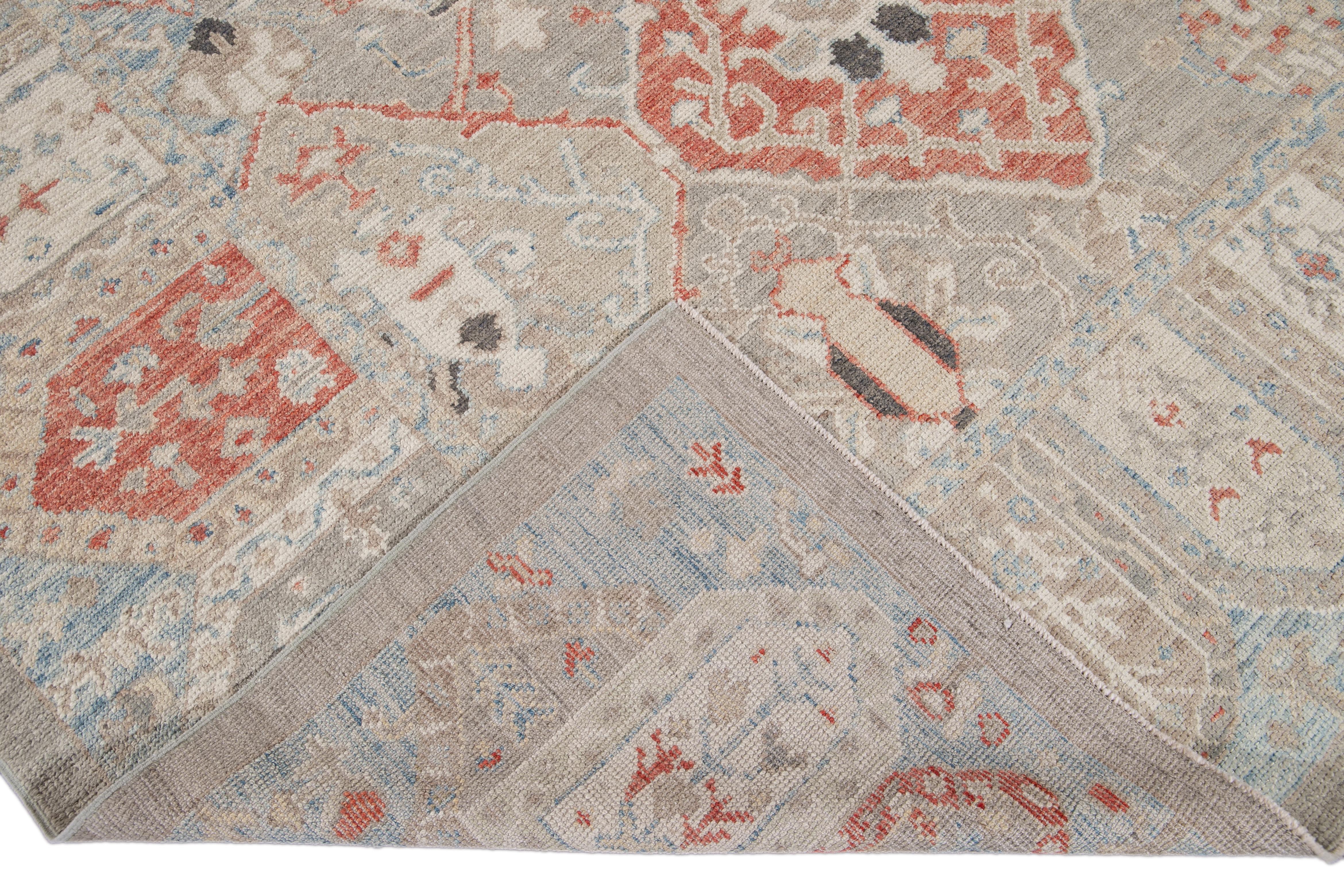 Beautiful modern Oushak hand knotted wool rug with a gray and beige field. This Oushak rug has orange, beige, blue, and ivory accents all-over a gorgeous geometric medallion floral design.

This rug measures 8'5