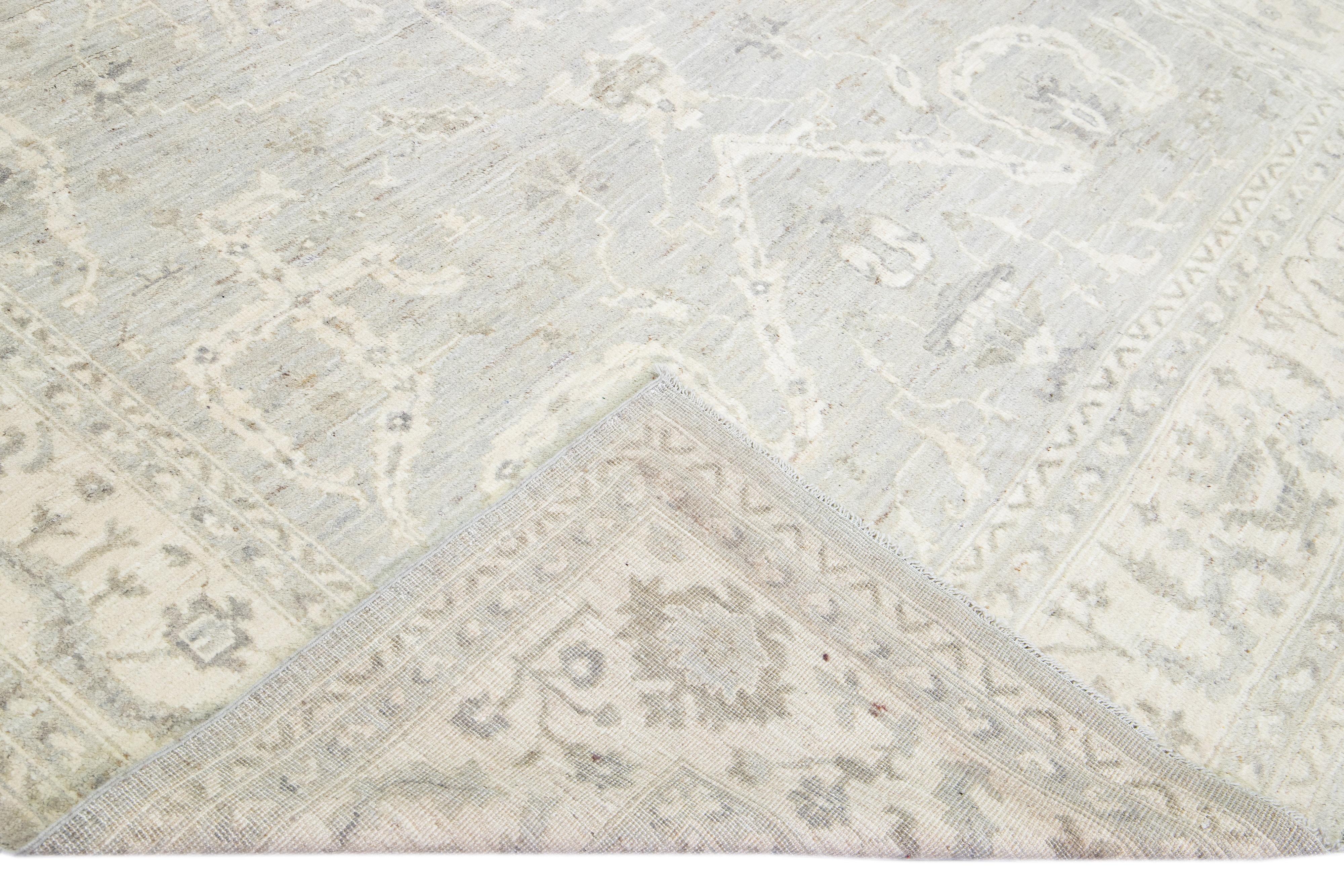 Beautiful modern Oushak hand-knotted wool rug with a gray field. This Oushak rug has beige and brown accents that feature a gorgeous geometric floral pattern design. 

This rug measures: 8'5