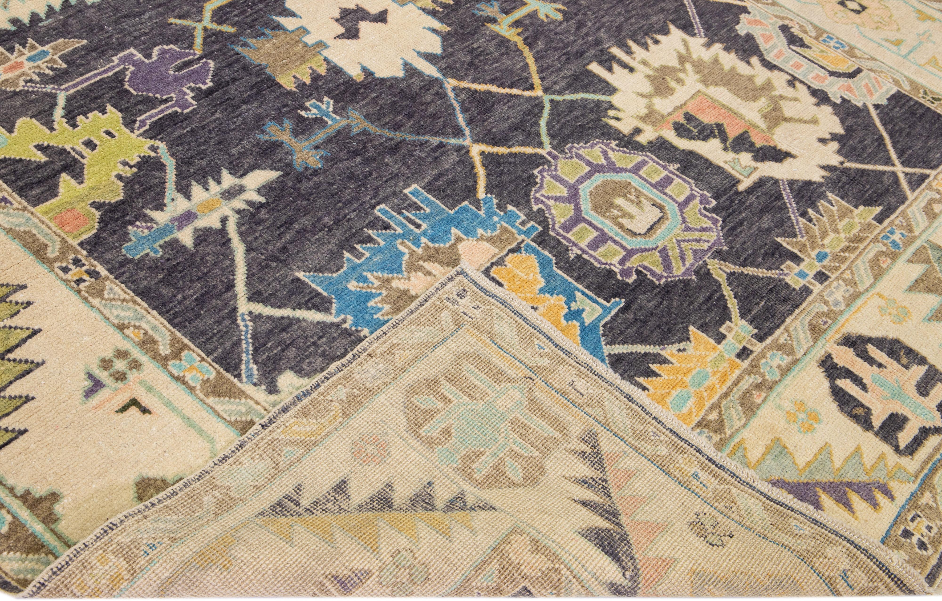 Schöner moderner Oushak-Teppich aus handgeknüpfter Wolle mit einem anthrazitfarbenen Feld. Dieser türkische Teppich hat einen beigefarbenen Rahmen mit mehrfarbigen Akzenten in einem prächtigen floralen Allover-Muster.

Dieser Teppich misst: 8'4