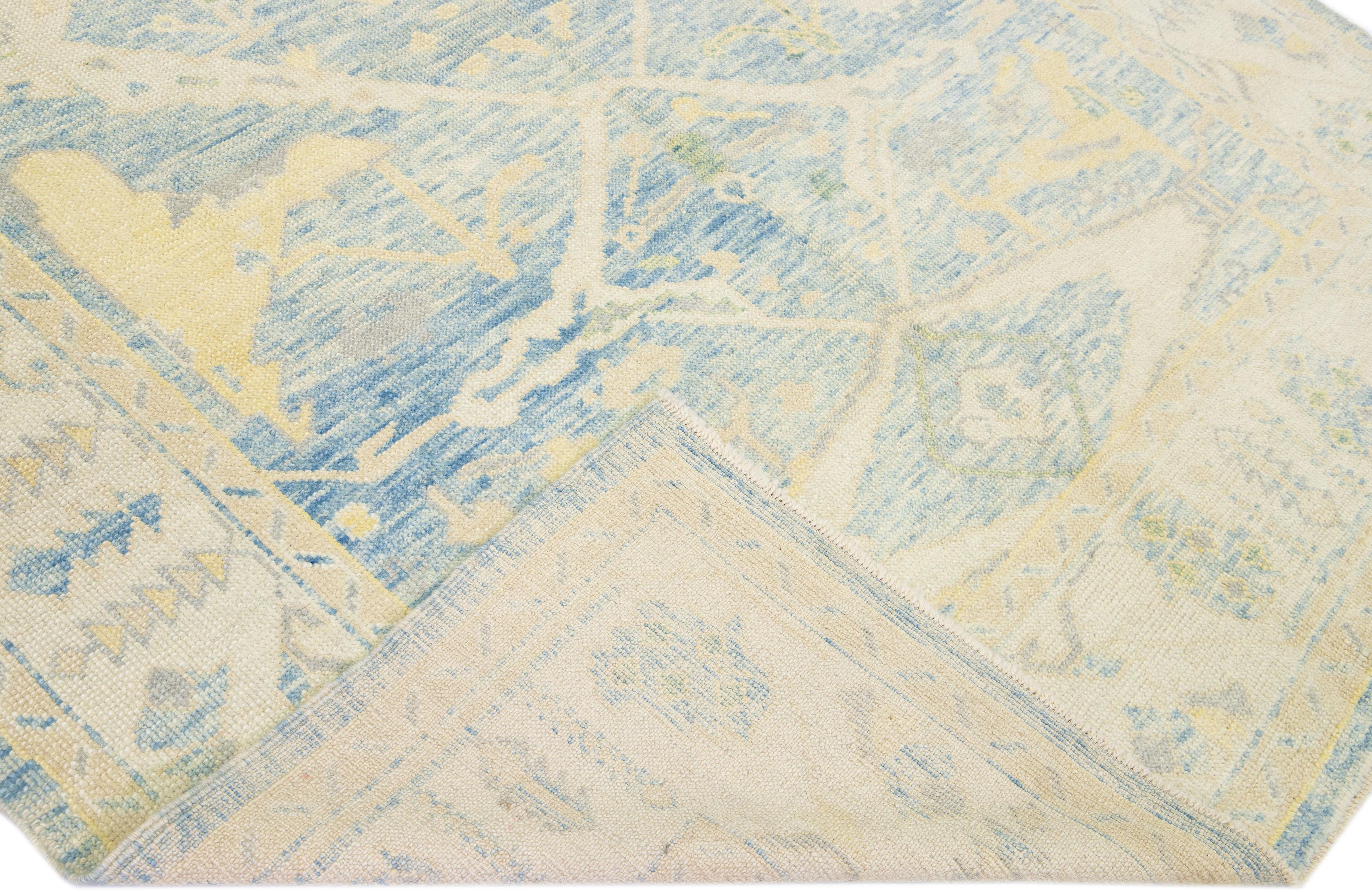 Beautiful modern Oushak hand-knotted wool rug with a blue color field. This Turkish Piece has yellow and beige accent colors in a gorgeous allover pattern.

This rug measures: 6'10