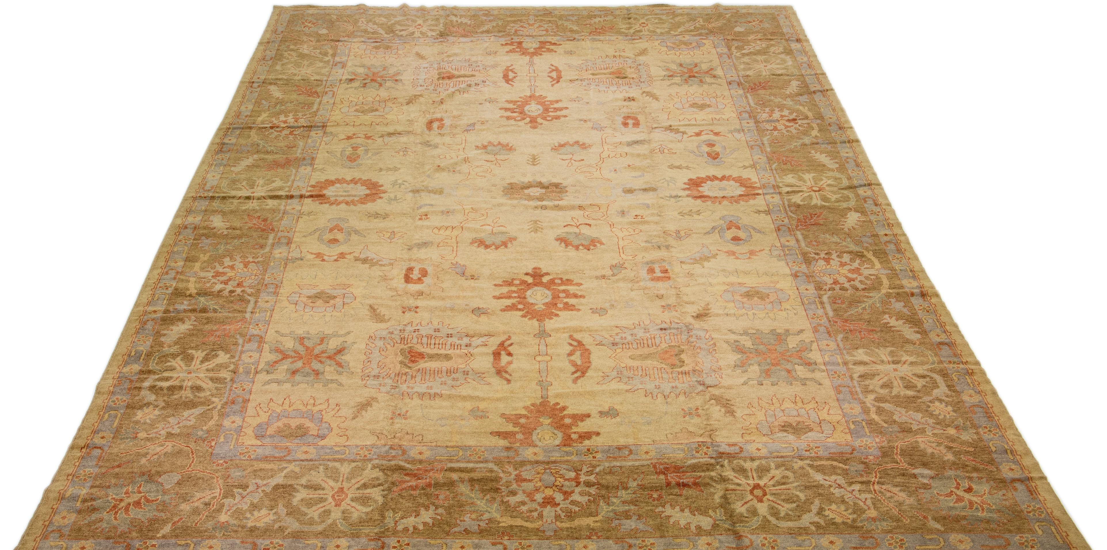Beautiful modern Turkish Oushak hand-knotted wool rug with a beige color field. This rug has brown, yellow, and rust accents in a gorgeous large-scale floral motif

This rug measures: 14'5
