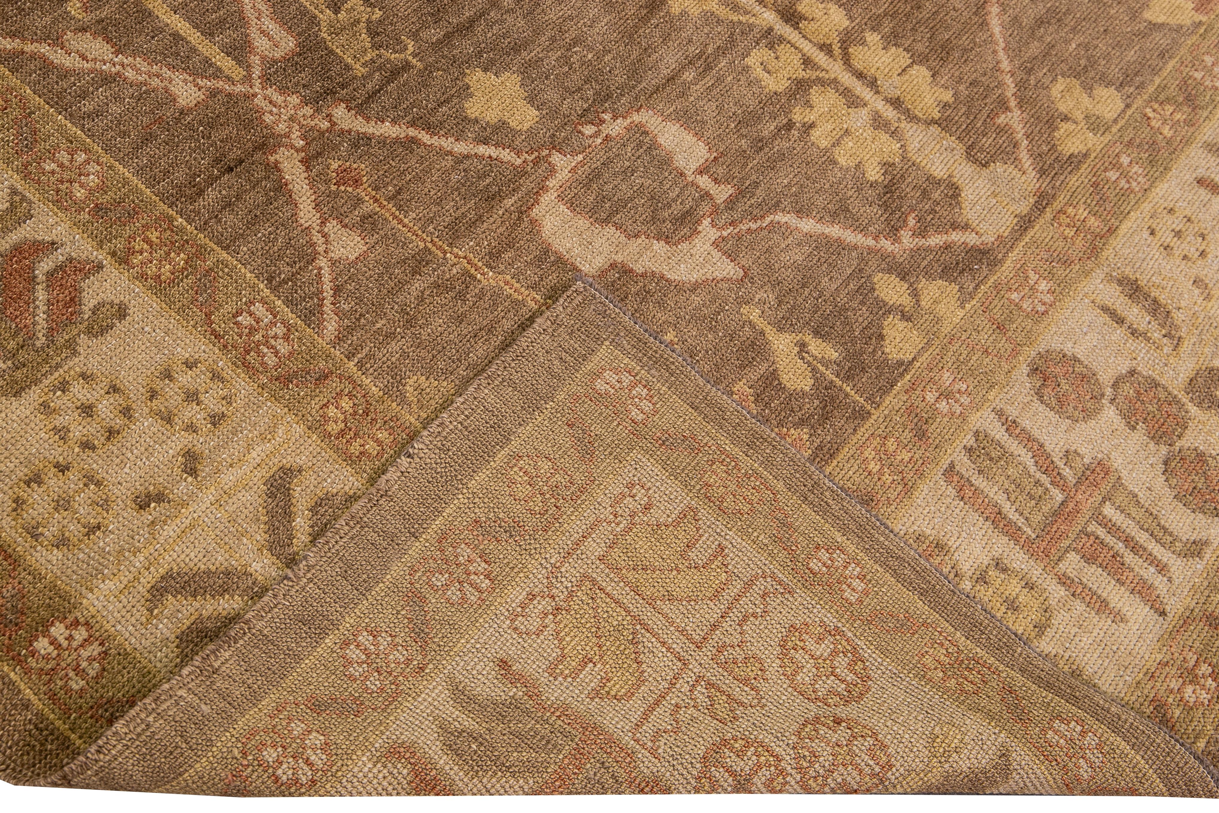 Beautiful Modern Turkish Oushak hand-knotted wool rug with a brown field. This Oushak has a beige frame and accents of golden, tan, and brown in an all-over geometric floral design.

This Rug measures: 7'10