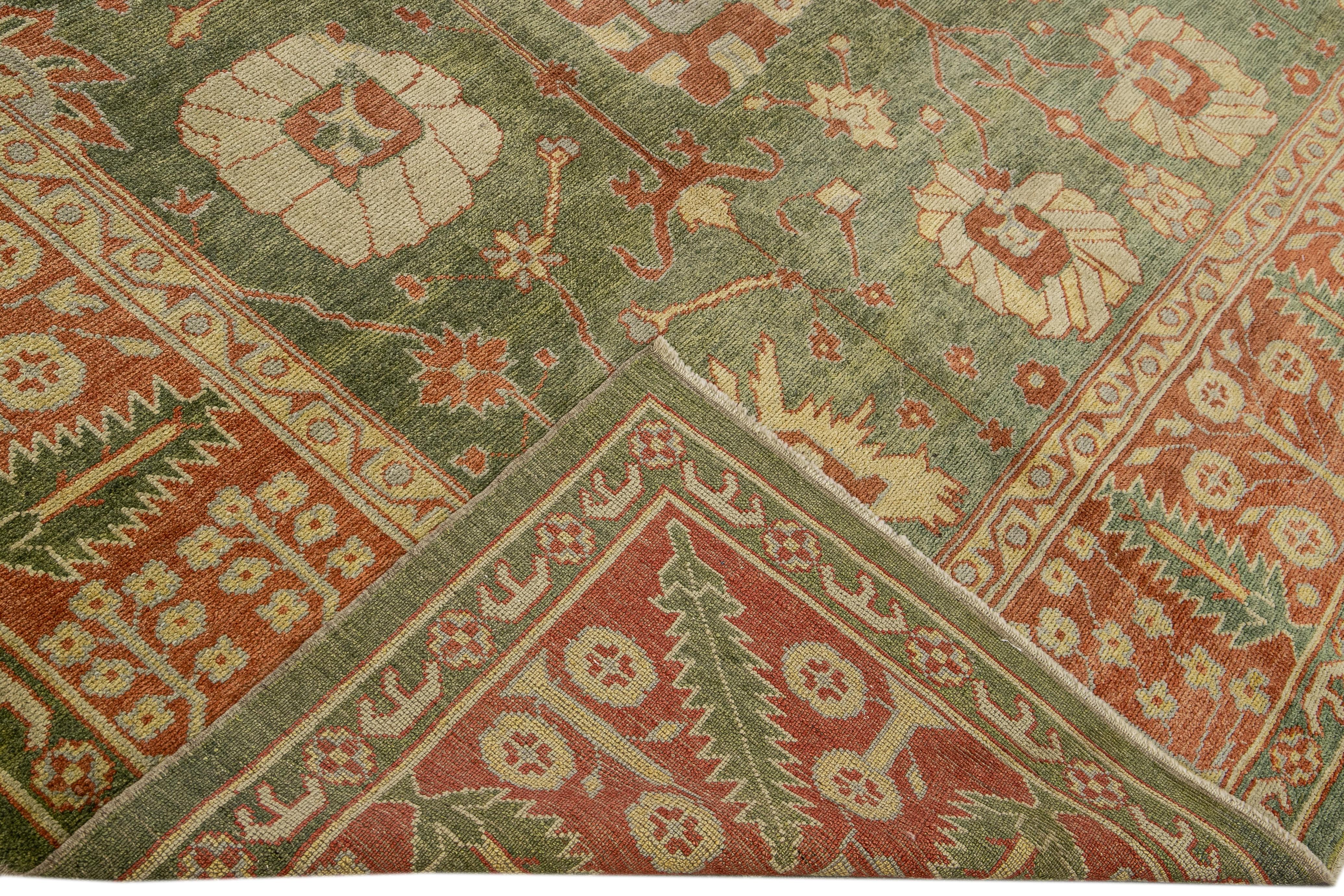 Beautiful modern Oushak hand-knotted wool rug with a green field. This Oushak rug has a brown frame and yellow and gray accents all over a gorgeous geometric floral motif.

This rug measures 9'11