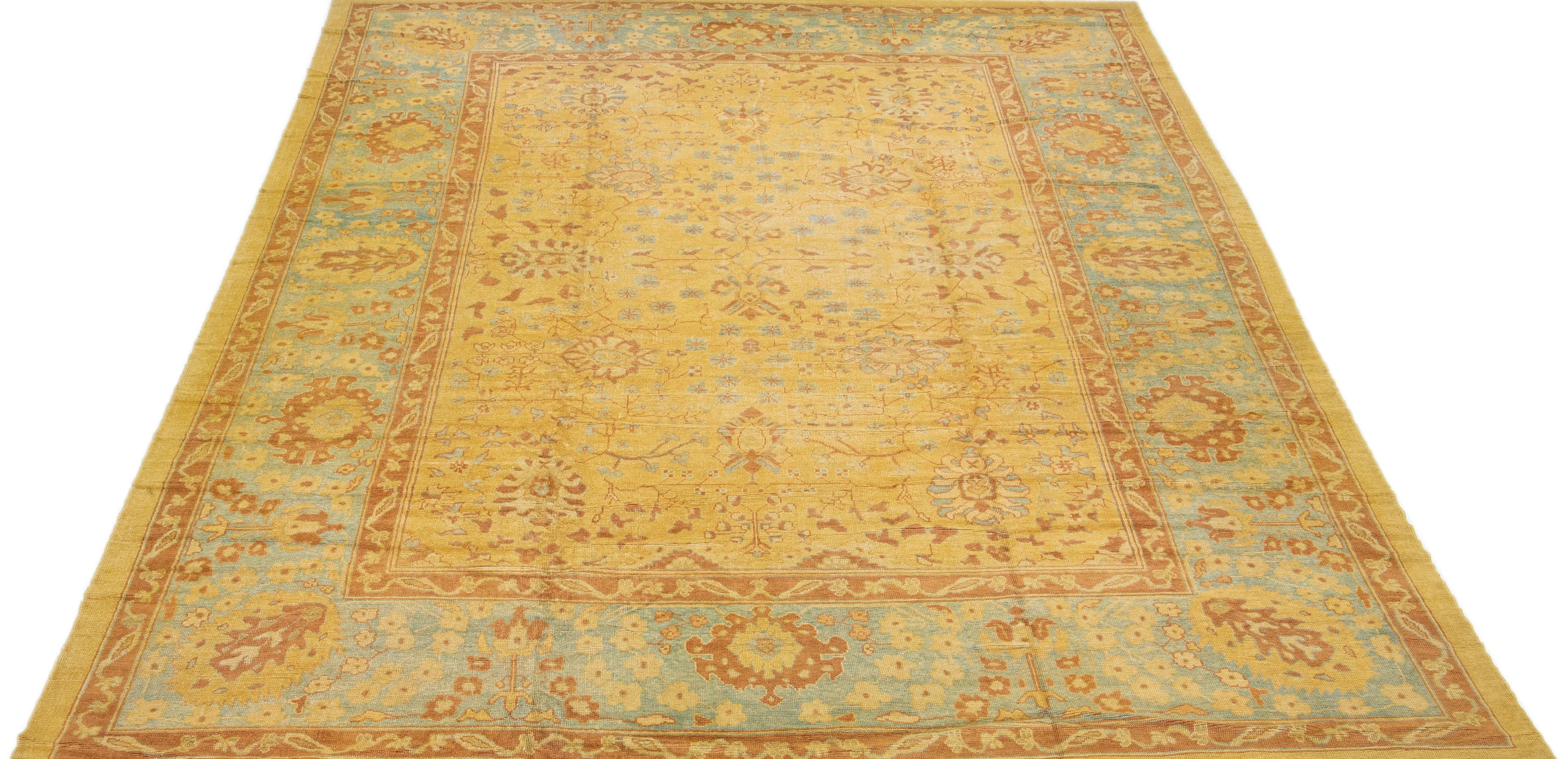 Beautiful Modern Turkish hand-knotted wool rug with a goldenrod color field. This rug has a blue designed frame with accent colors of brown and beige in a gorgeous all-over geometric floral design.

This rug measures: 14'6