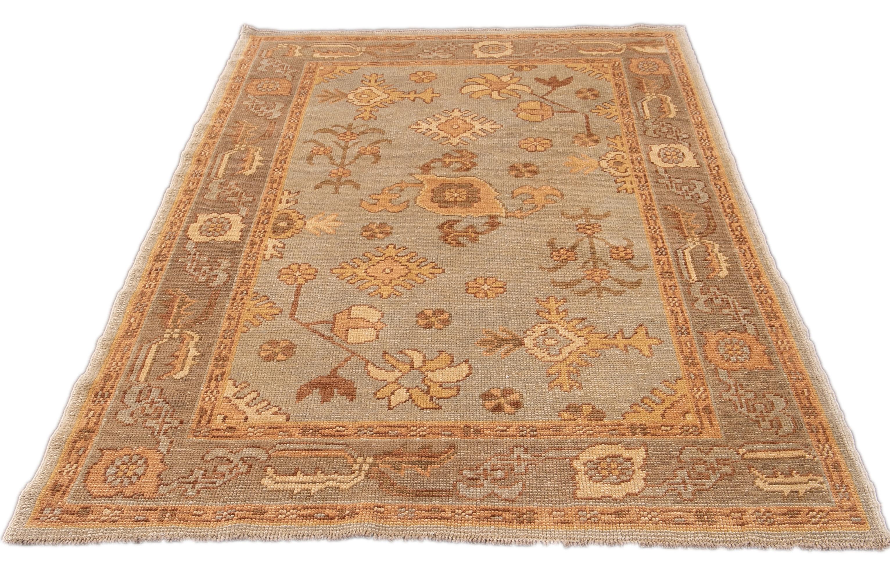 Schöner moderner türkischer Oushak handgeknüpfter Wollteppich mit einem hellblauen Feld. Dieser Oushak hat Akzente und einen Rahmen aus Gelb, Hellbraun und Grün in einem geometrischen Blumenmuster.

Dieser Teppich misst: 4'2