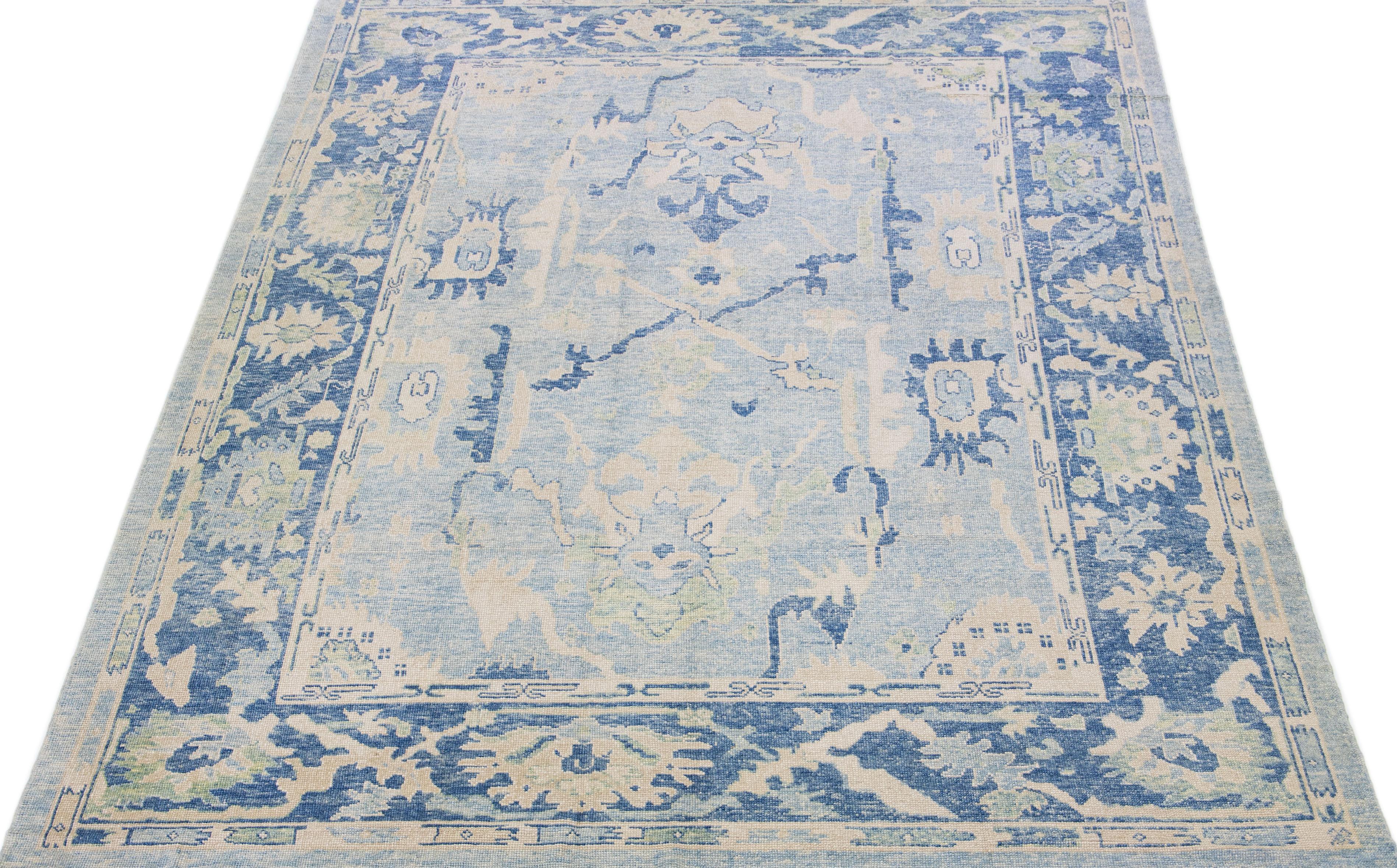 Beautiful modern Oushak hand-knotted wool rug with a light blue color field. This Turkish Piece has beige and green accent colors in a gorgeous all-over floral design.

This rug measures: 10'1