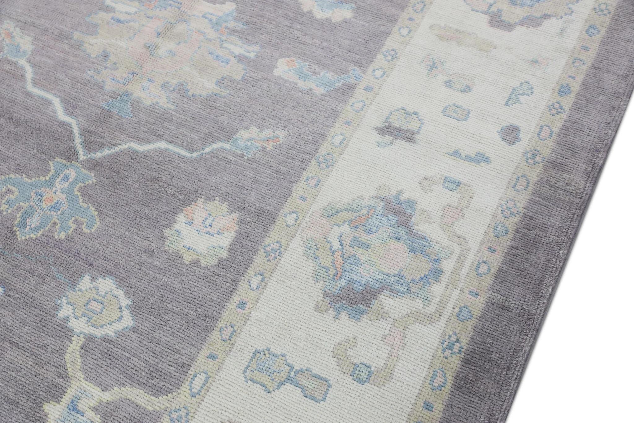 This modern Turkish oushak rug is a stunning piece of art that has been handwoven using traditional techniques by skilled artisans. The rug features intricate patterns and a soft color palette that is achieved through the use of natural vegetable