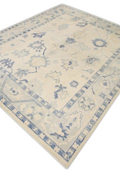 Alfombra Oushak turca de lana tejida a mano en color crema con diseño floral azul 8' x 9'5