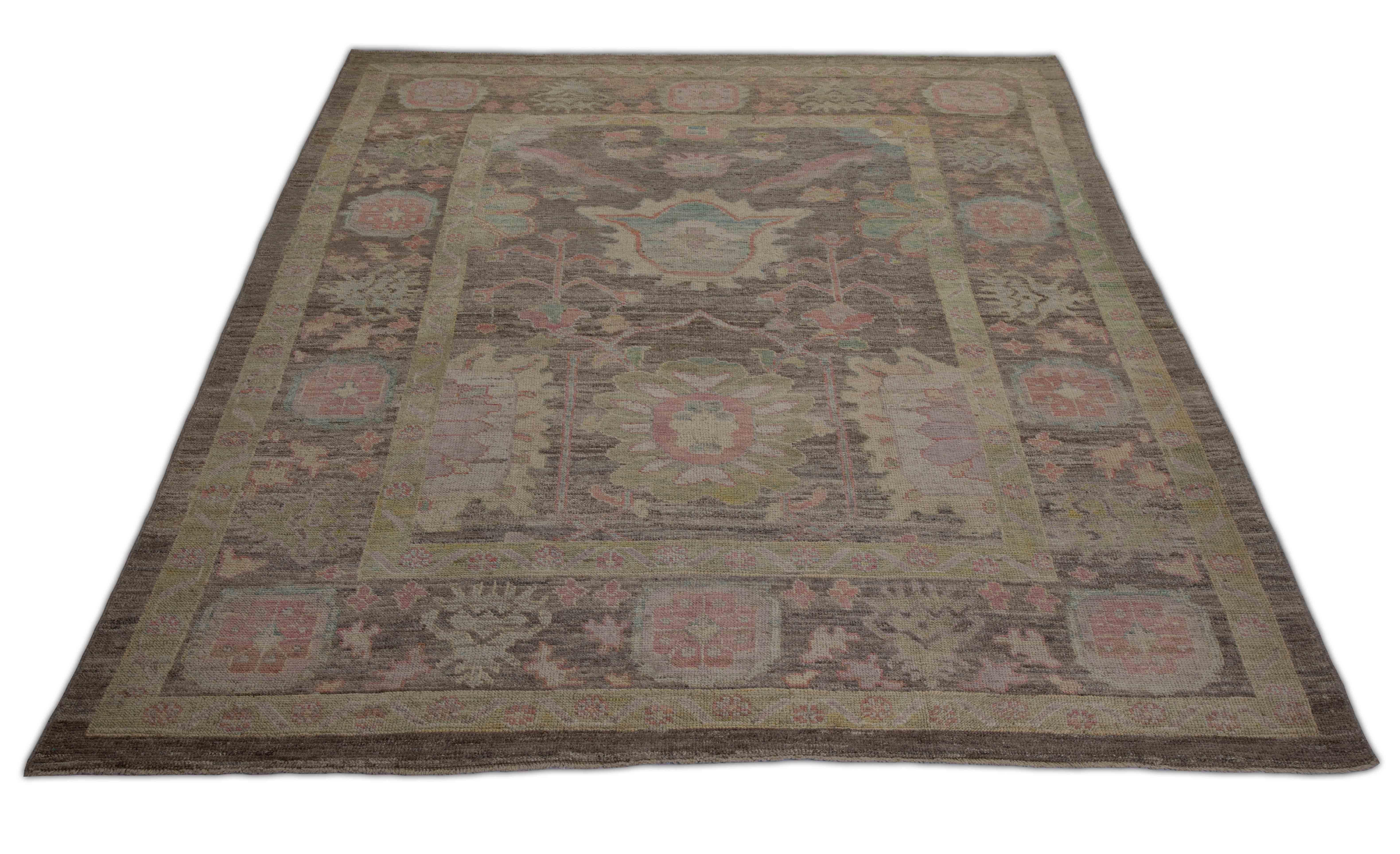 Contemporary Turkish rug made of handwoven sheep’s wool of the finest quality. It’s colored with organic vegetable dyes that are certified safe for humans and pets alike. It features a large, brown field with big flower heads in pink associated with