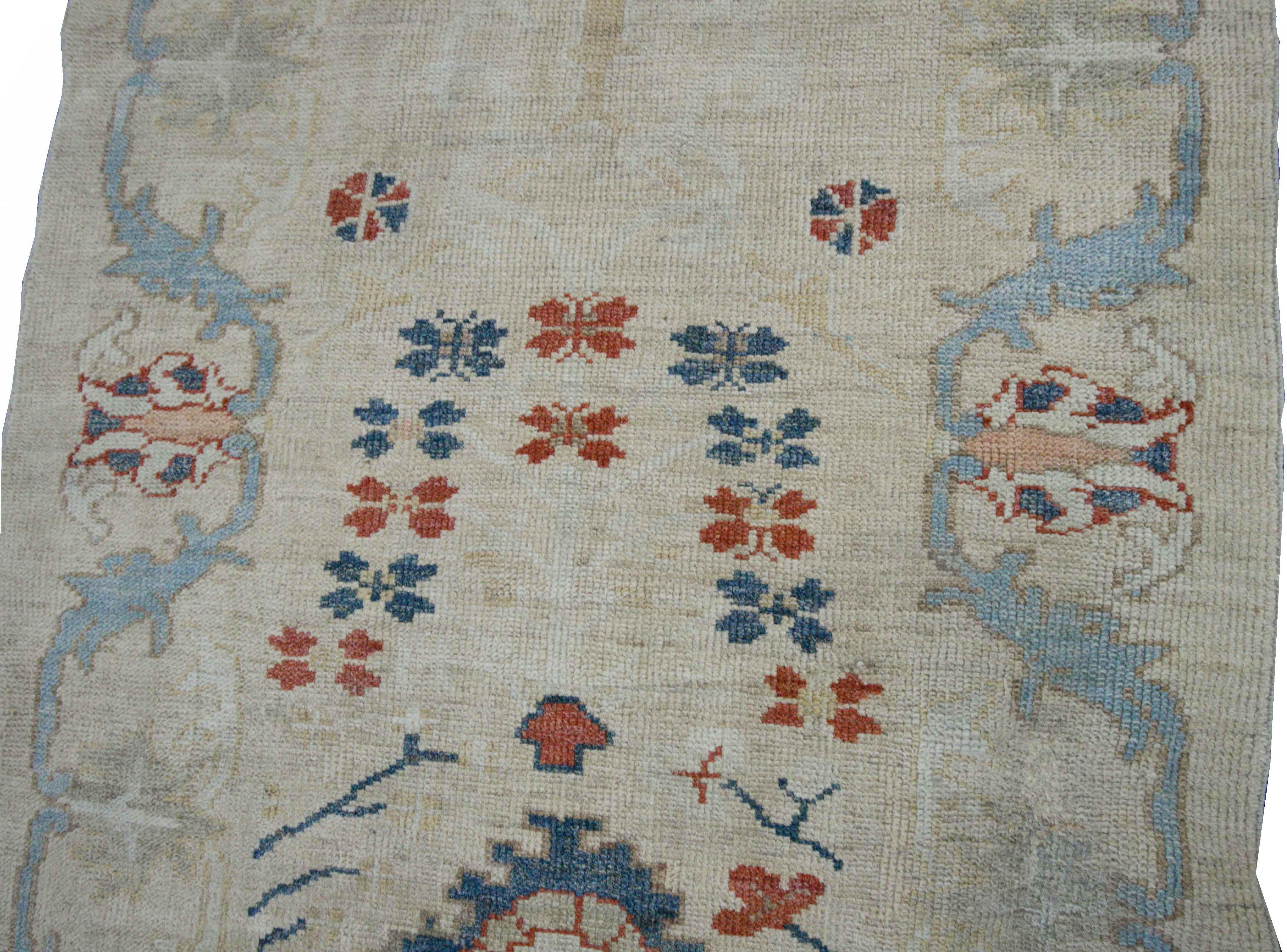 Modern Turkish rug made of handwoven sheep’s wool of the finest quality. It’s colored with organic vegetable dyes that are certified safe for humans and pets alike. It features an ivory field with unique floral details in red, blue and navy