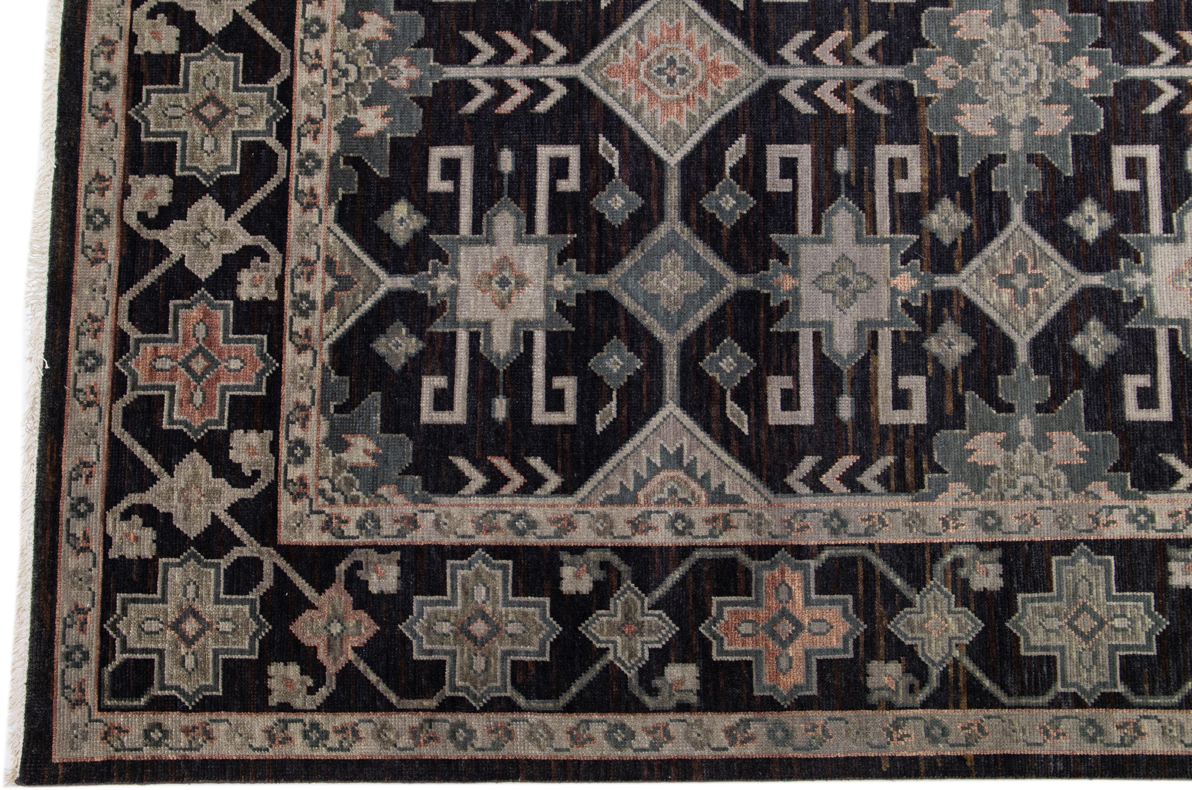 Beautiful modern Oushak hand-knotted wool rug with a charcoal field. This Turkish rug has a designed frame with gray, beige, and peach accents in a gorgeous all-over geometric floral design.

This rug measures: 10'1