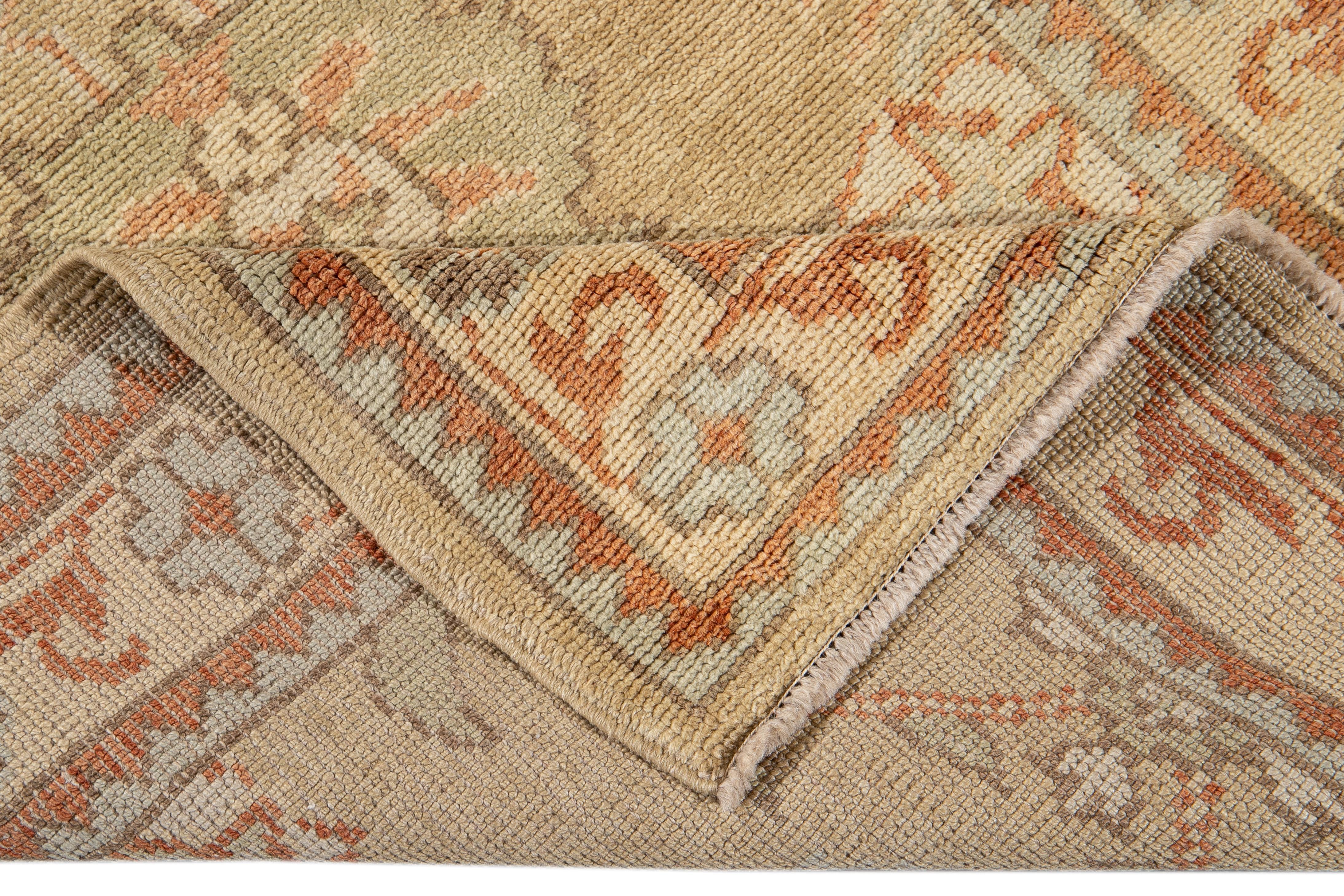 Beautiful modern Turkish Oushak hand-knotted wool runner with a tan field. This Oushak runner has a beige frame and accents of blue and orange in a gorgeous all-over geometric floral design.

This runner measures: 3' 3